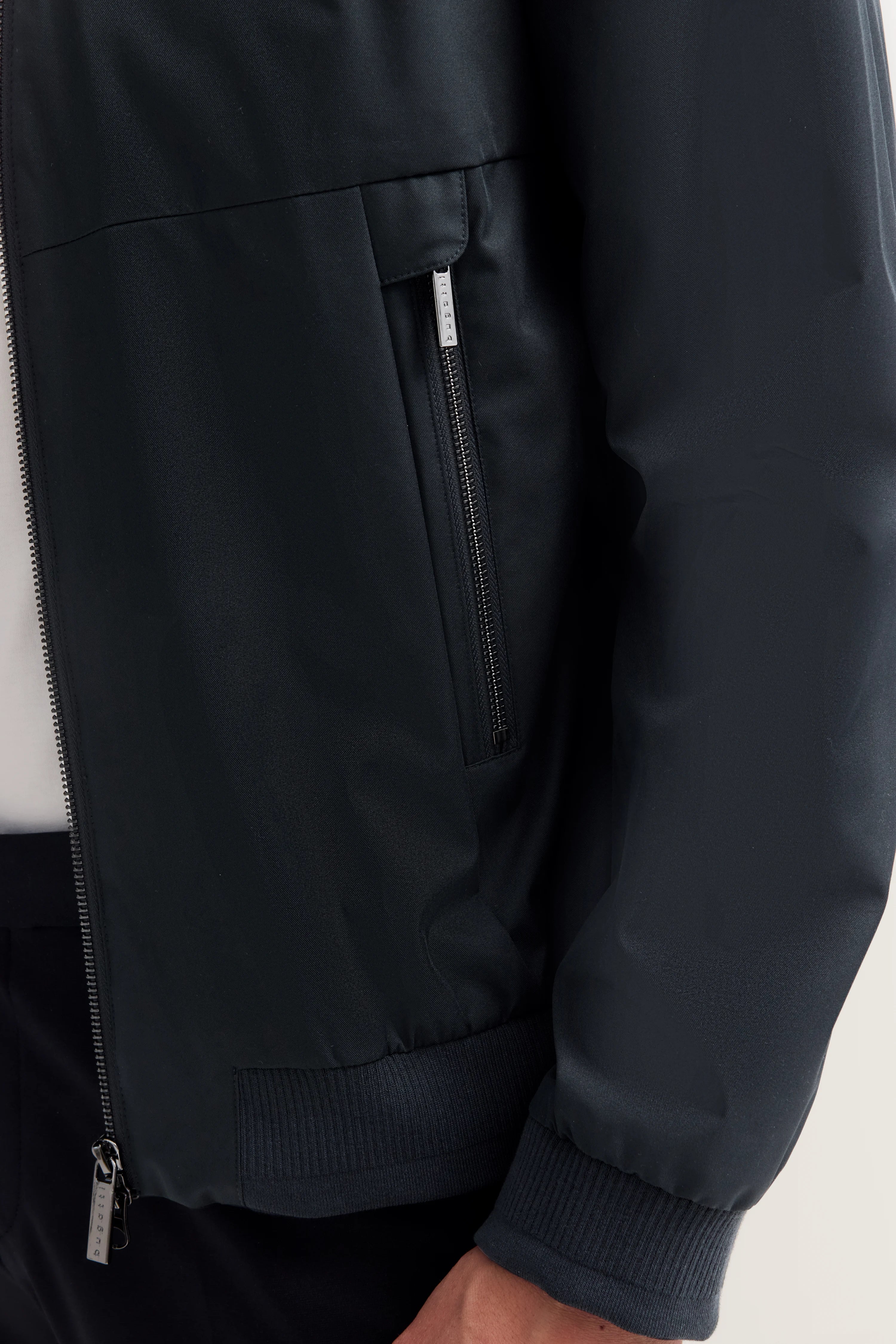Dunkelblaue bugatti Jacke, Detailaufnahme, Reißverschluss und Tasche sichtbar.
