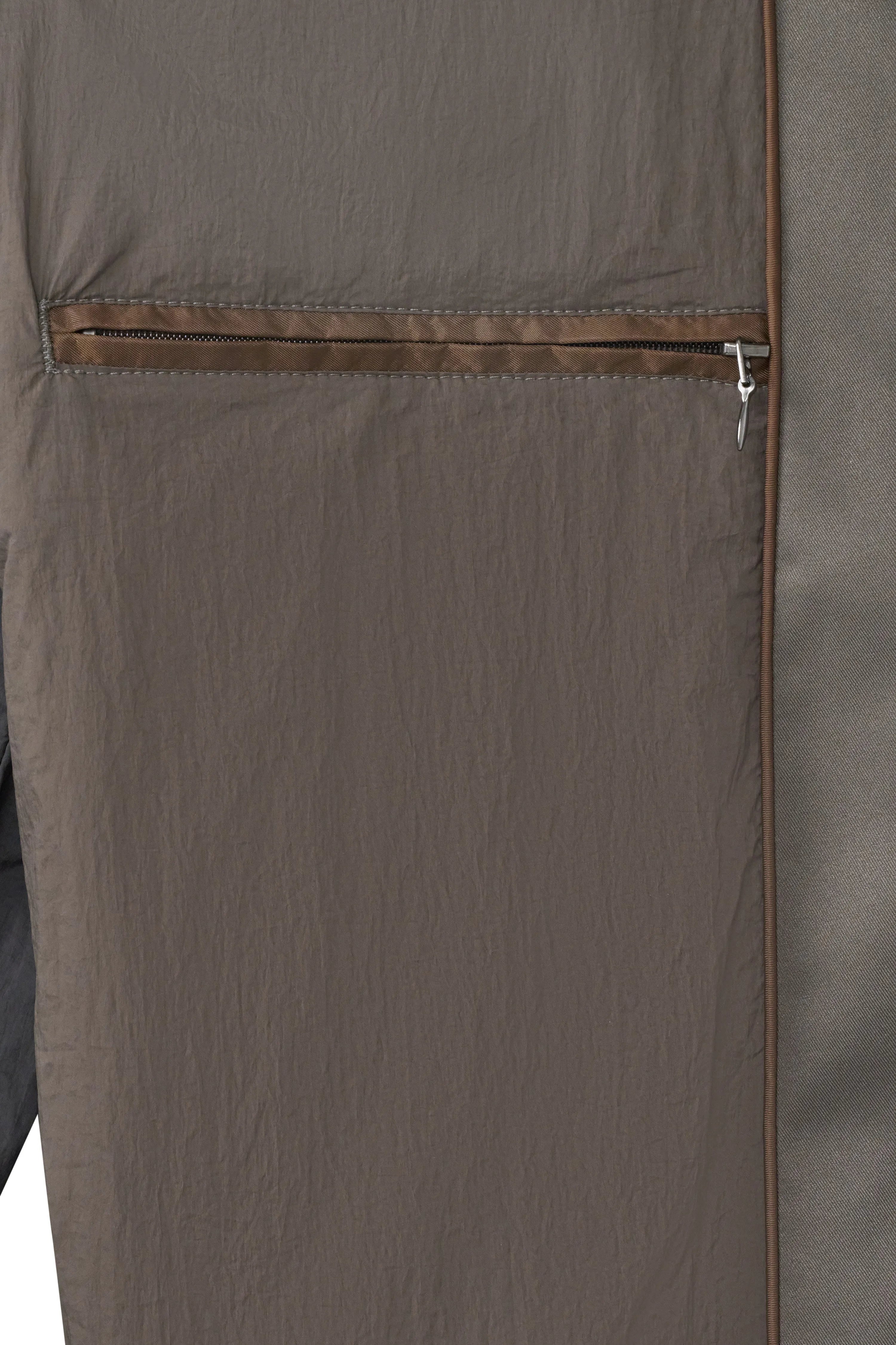 Grijs-bruine bugatti mantelstof met ritssluiting detail. Buste afbeelding, focus op textuur en design.
