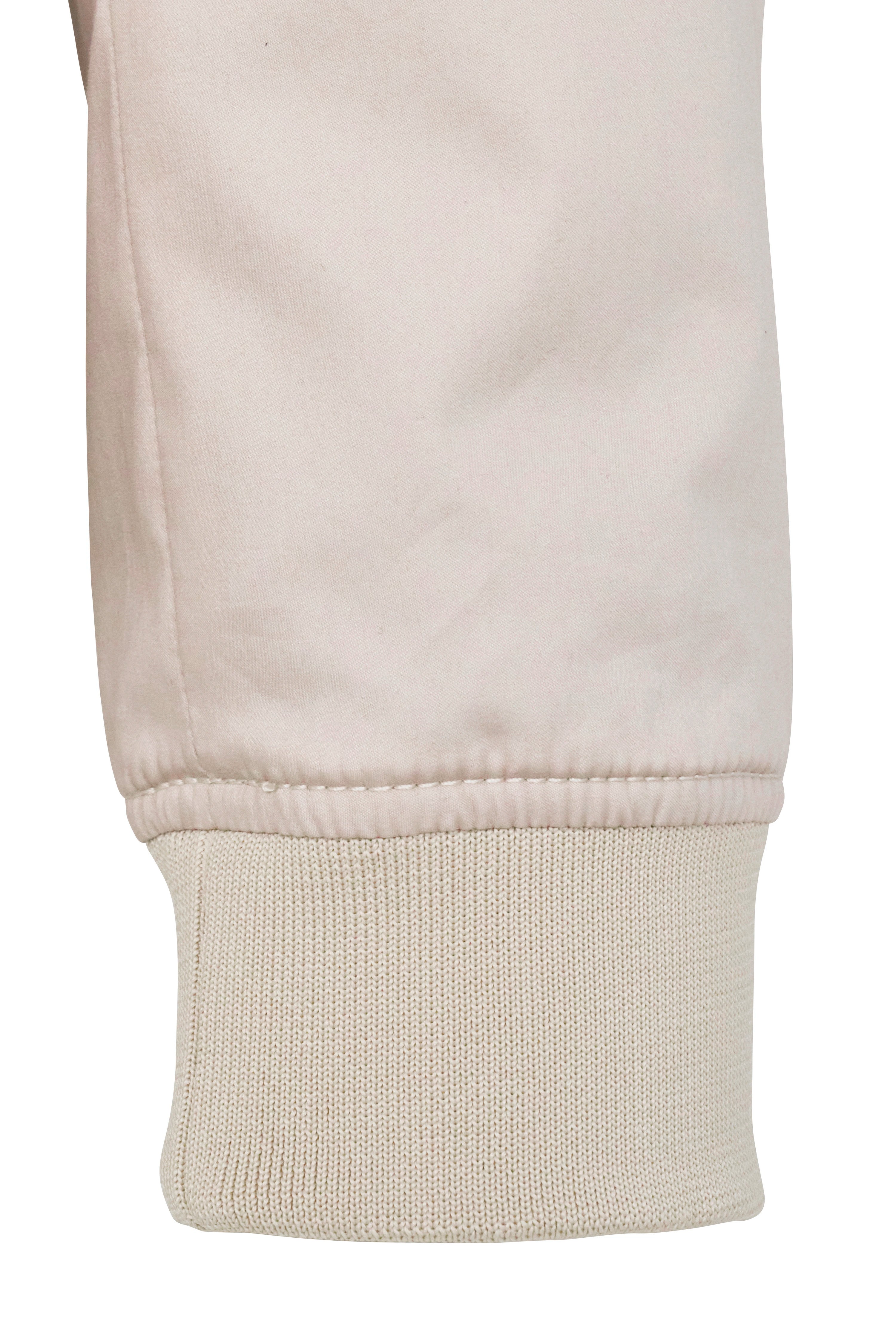 Beigefarbener Ärmelabschluss mit Bündchen aus Baumwolle, Detailaufnahme, bugatti Stil und Qualität.