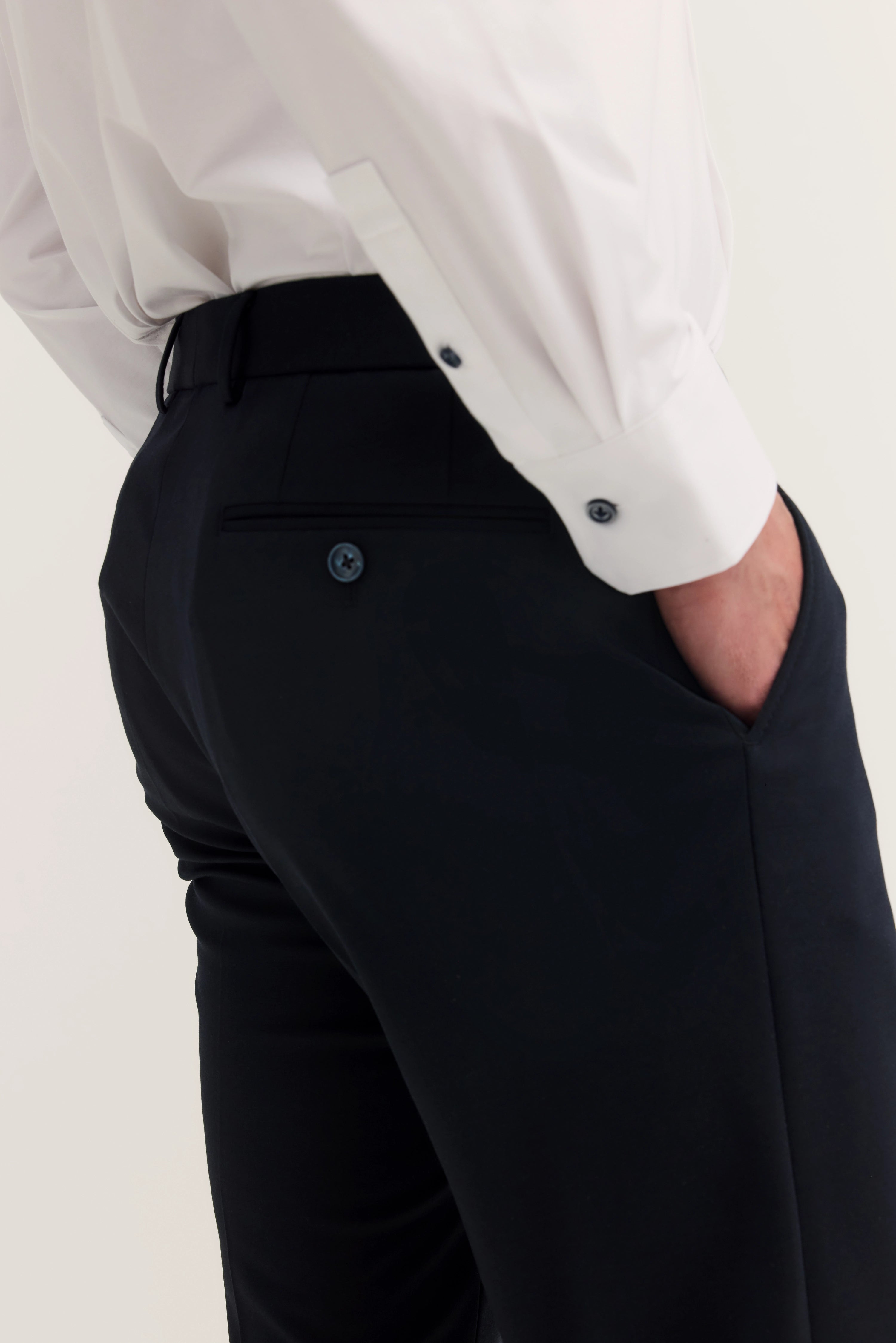 White bugatti shirt sleeves, black trousers, casual bust view.