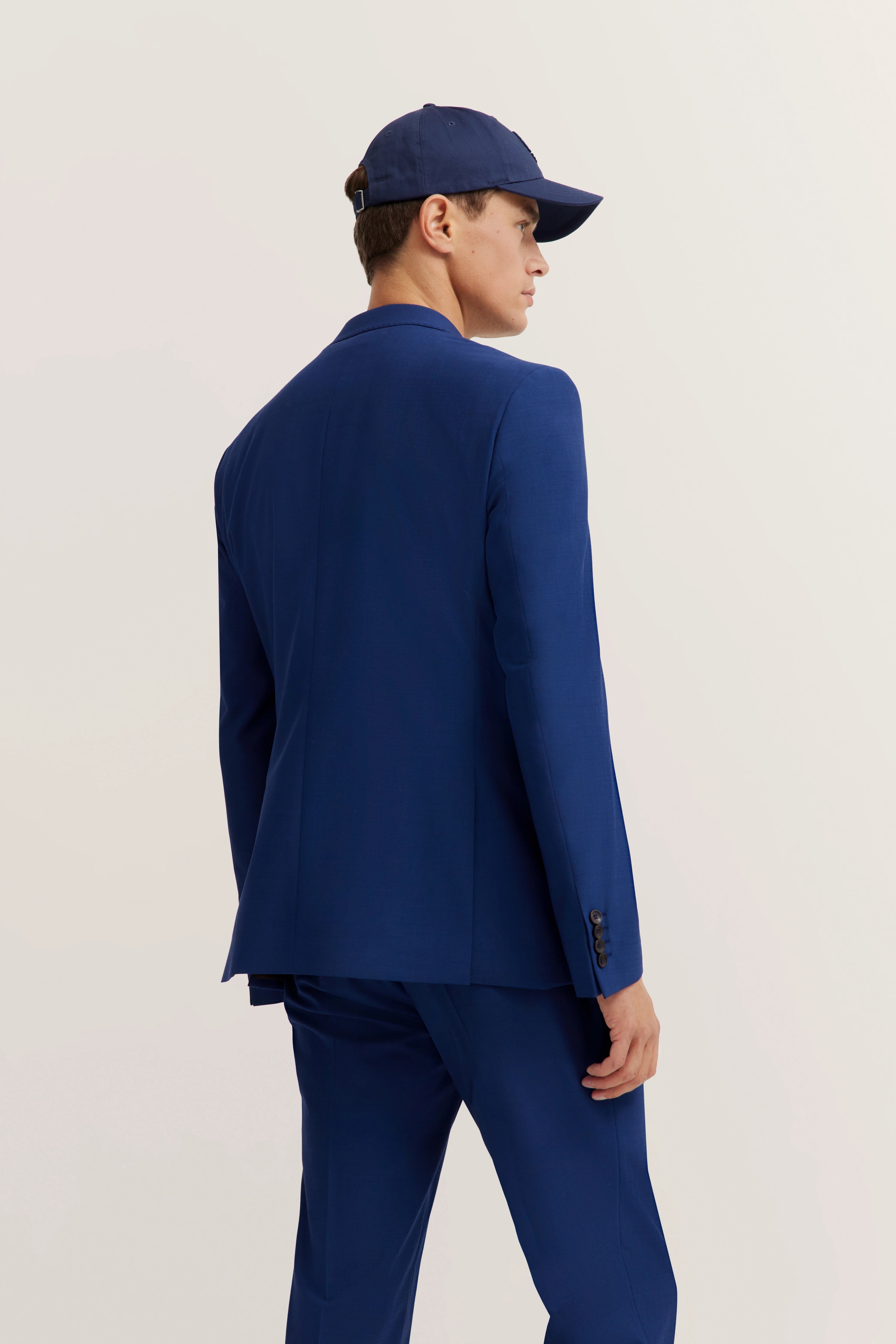 Blue suit with matching cap, model from behind, bugatti style.