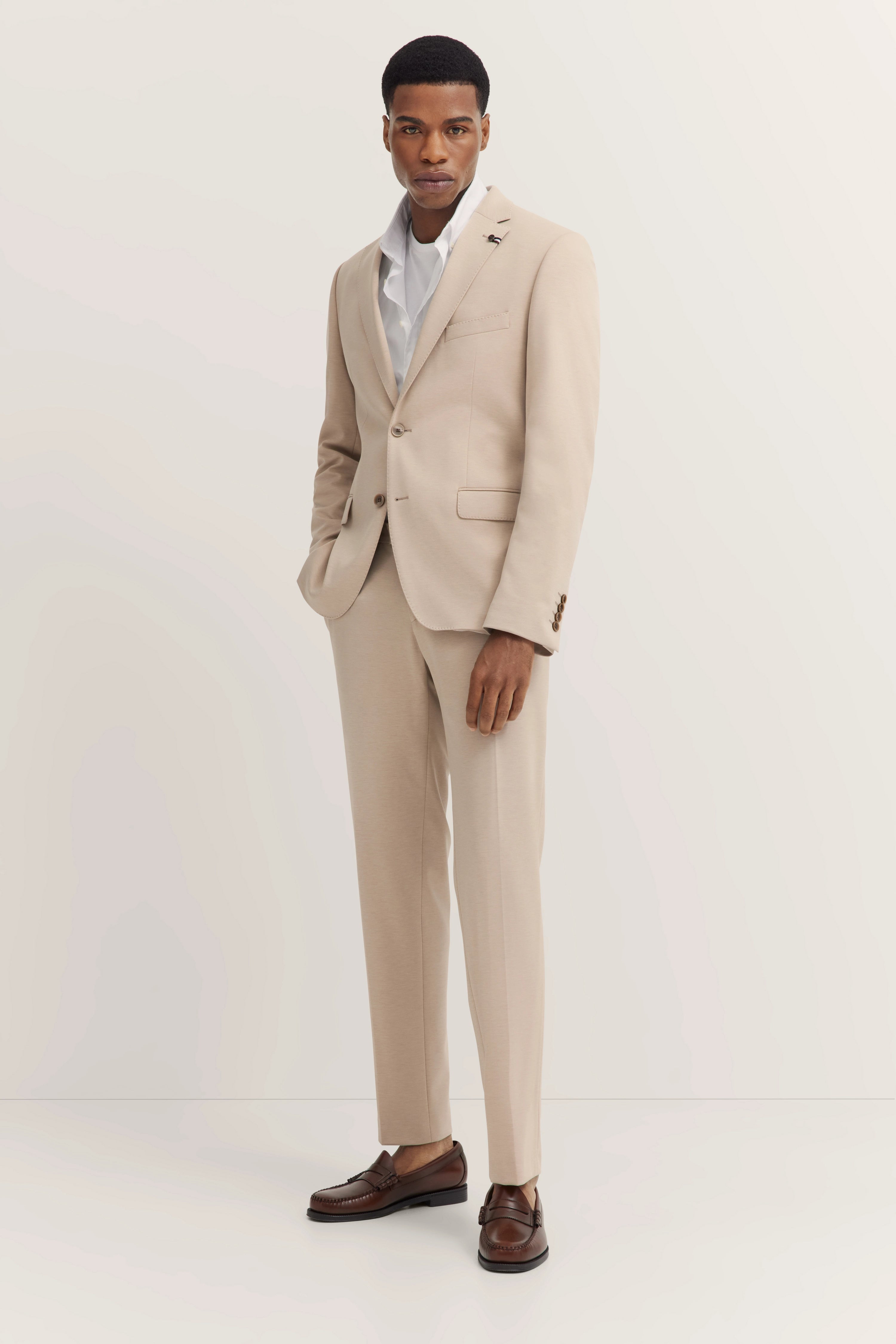 Elegant bugatti suit in beige, model posing relaxed, classic and stylish combination.