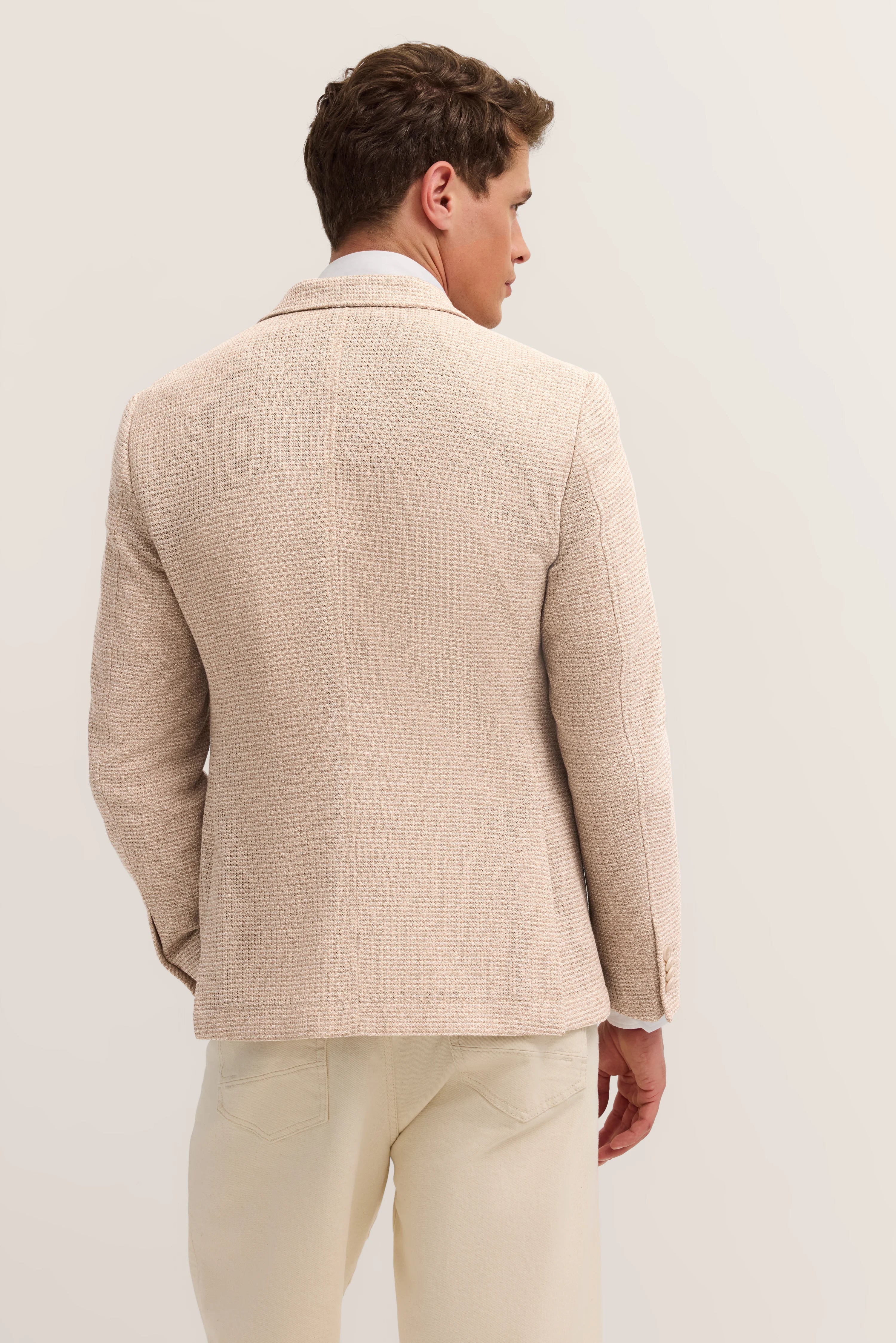 Beige bugatti Sakko mit Textur, Modelbild von hinten, entspannte Haltung.