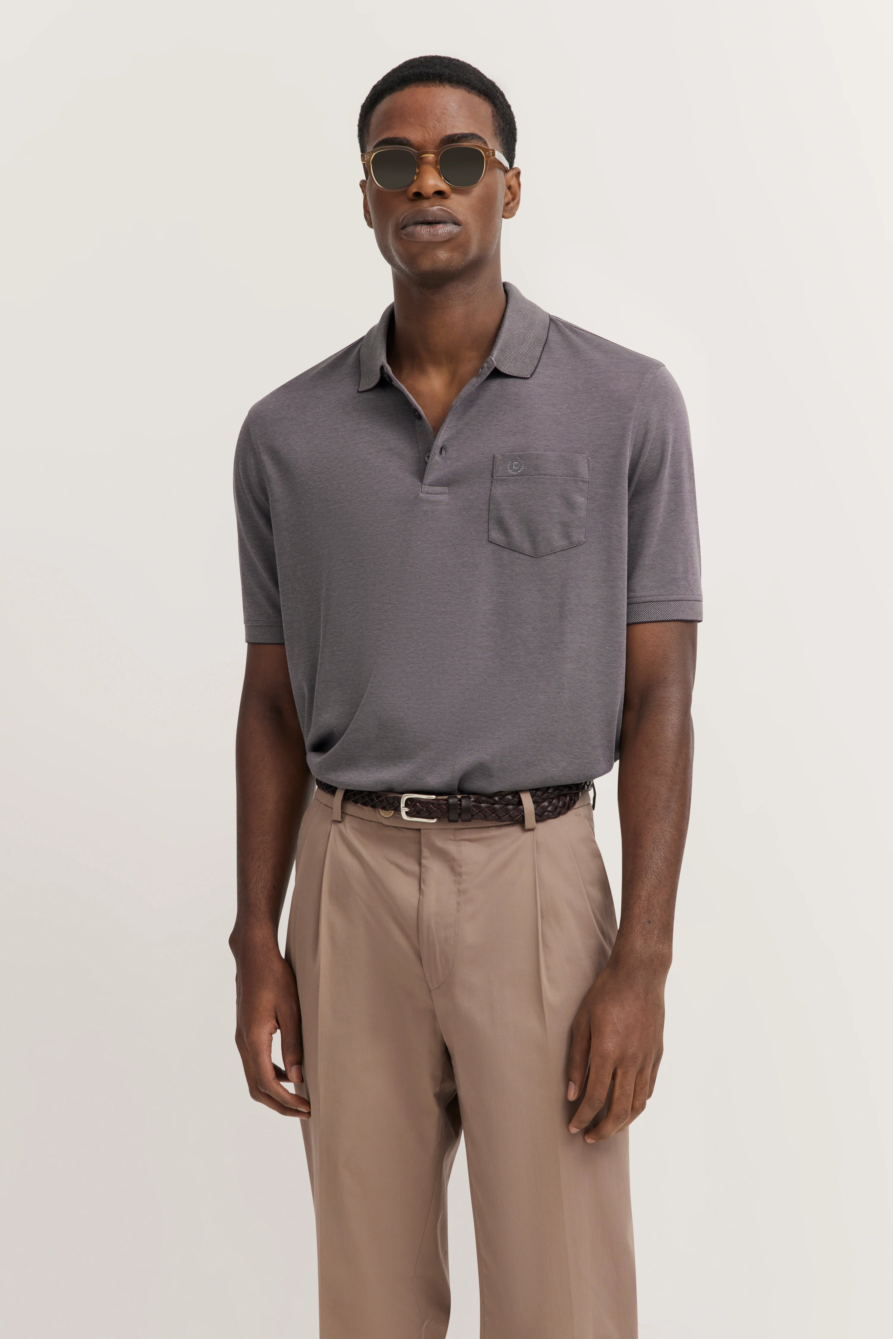 Gray bugatti polo shirt and beige pants, model posing casually.