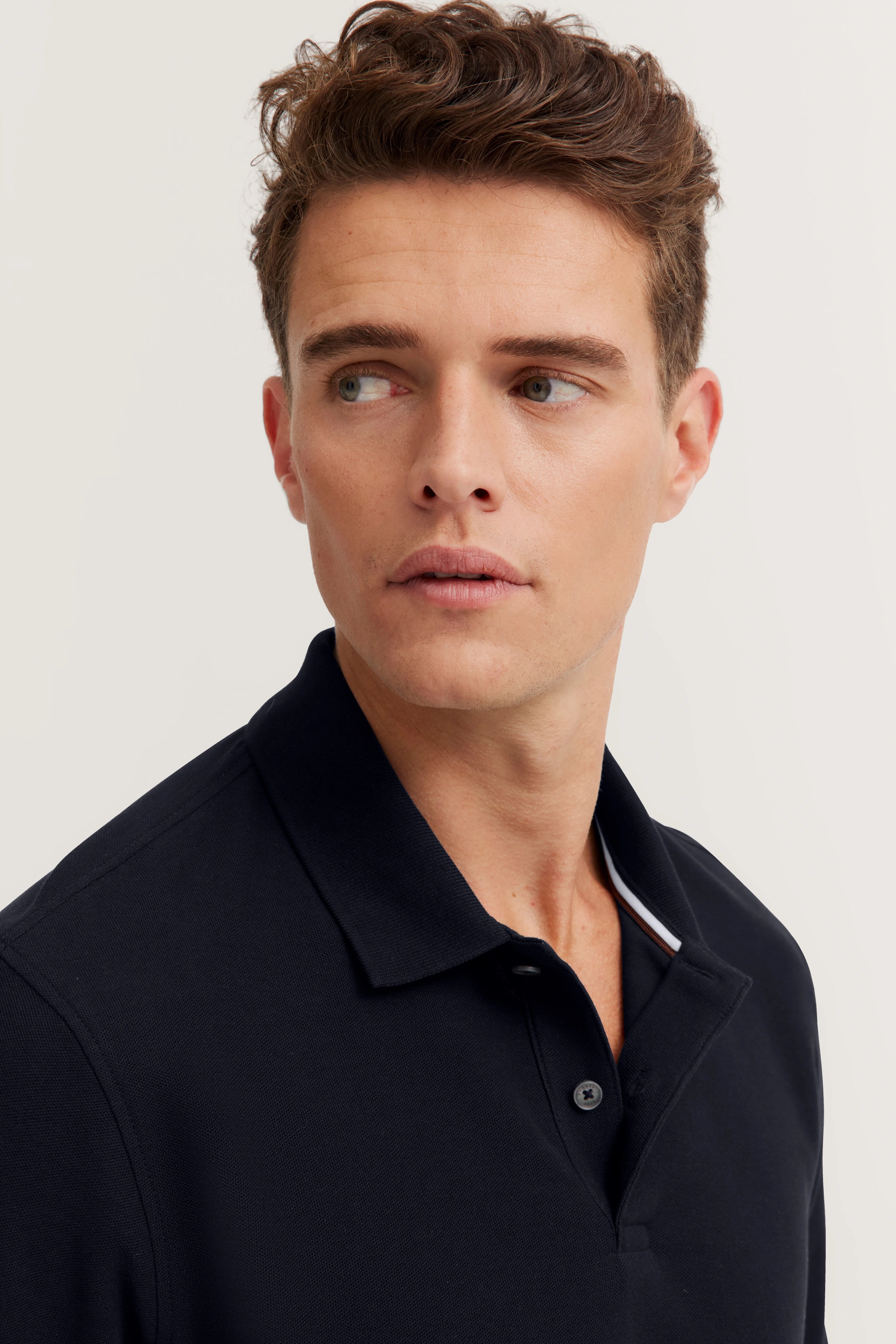 Navy blue bugatti long-sleeve polo shirt, bust view, classic design.