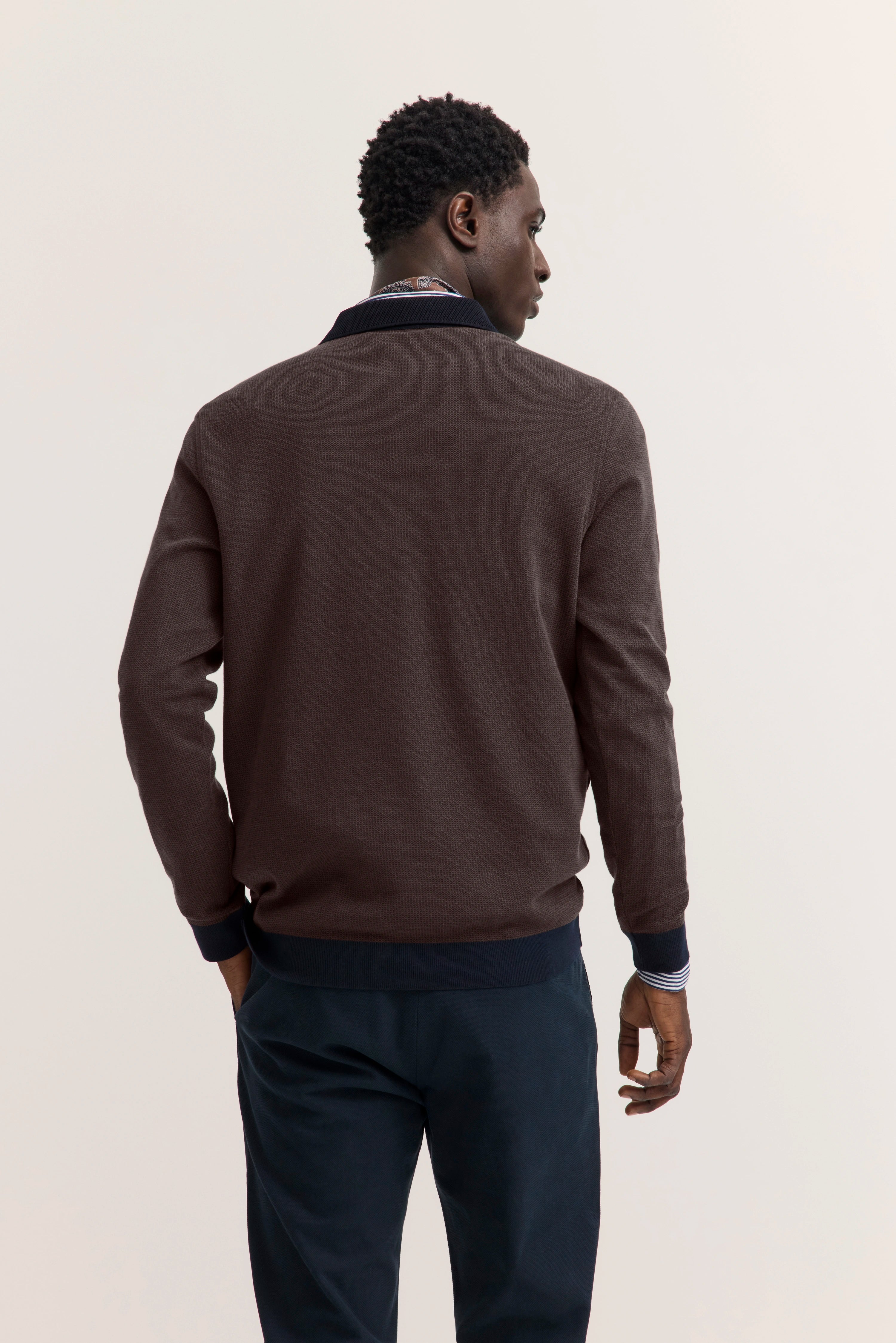 bugatti Pullover braun, Modelbild von hinten, legeres Posing, dunkle Hose.