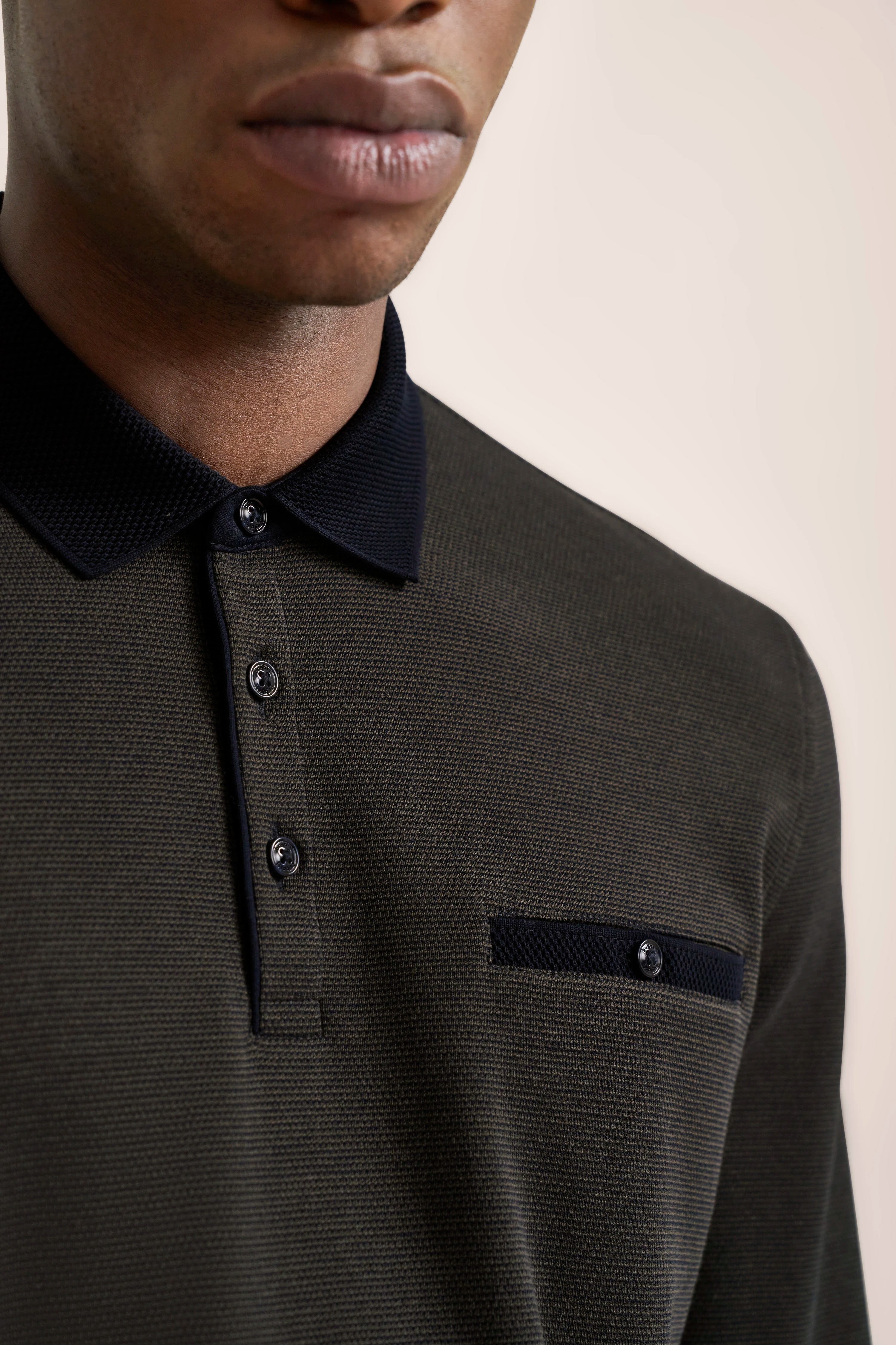 Dunkelgrünes bugatti Polohemd mit schwarzem Kragen und Knopfleiste, legeres Büstenbild.