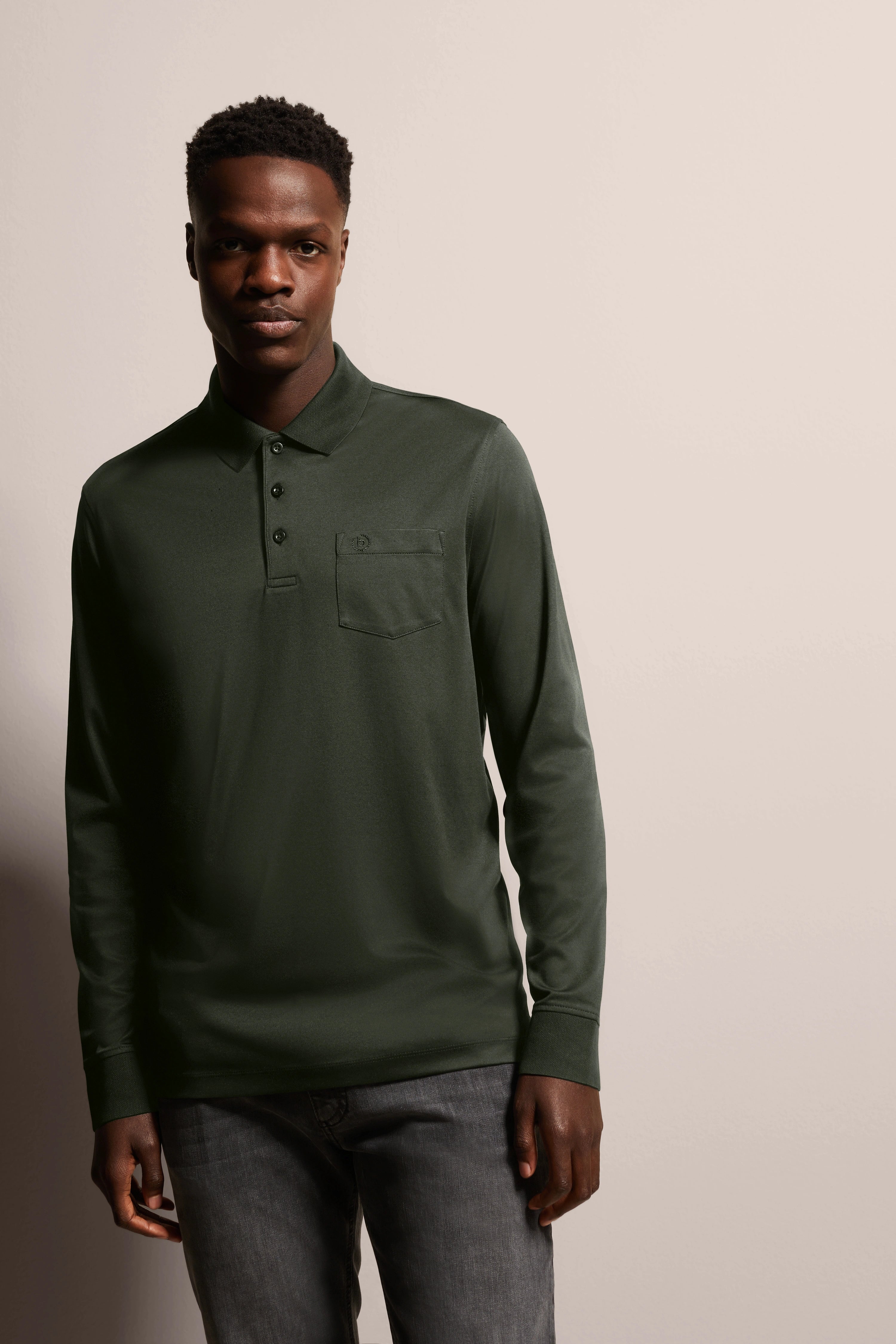 bugatti outfit: Dark green polo shirt, model pose, casual elegance, timeless style.