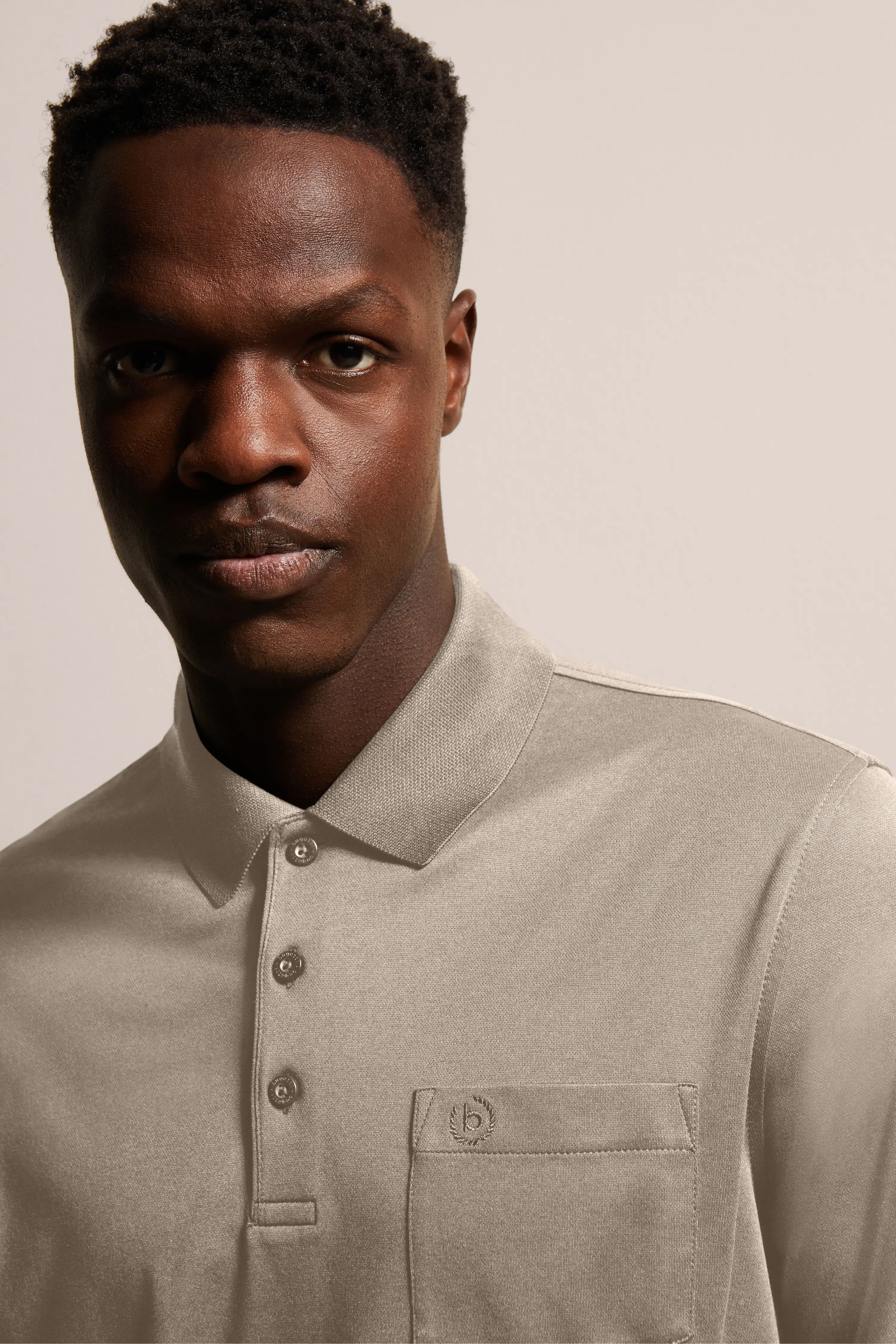 Bust of a man in a beige bugatti polo shirt with collar and button placket.