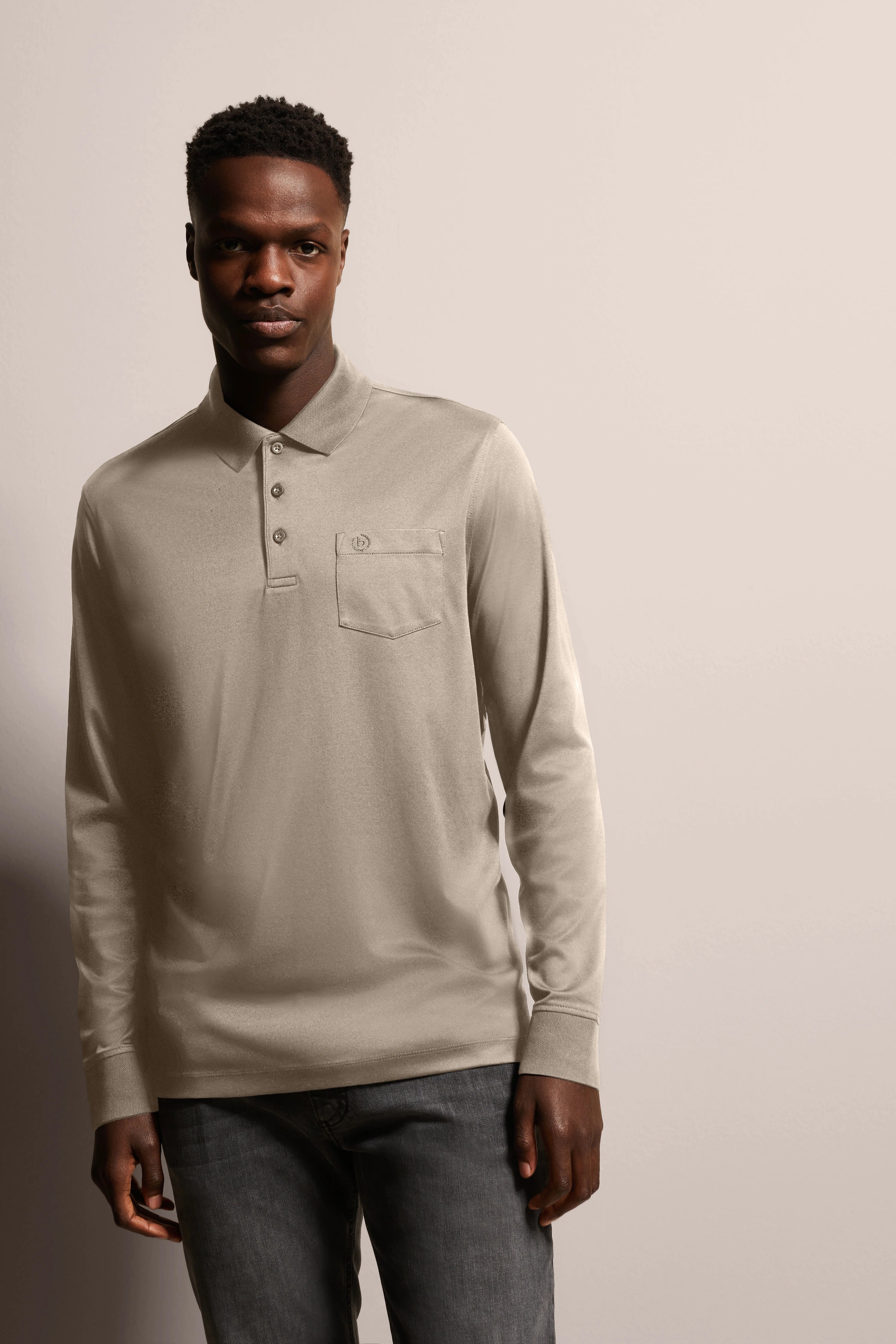 Beige bugatti long-sleeve polo on model, casual pose, paired with dark jeans.