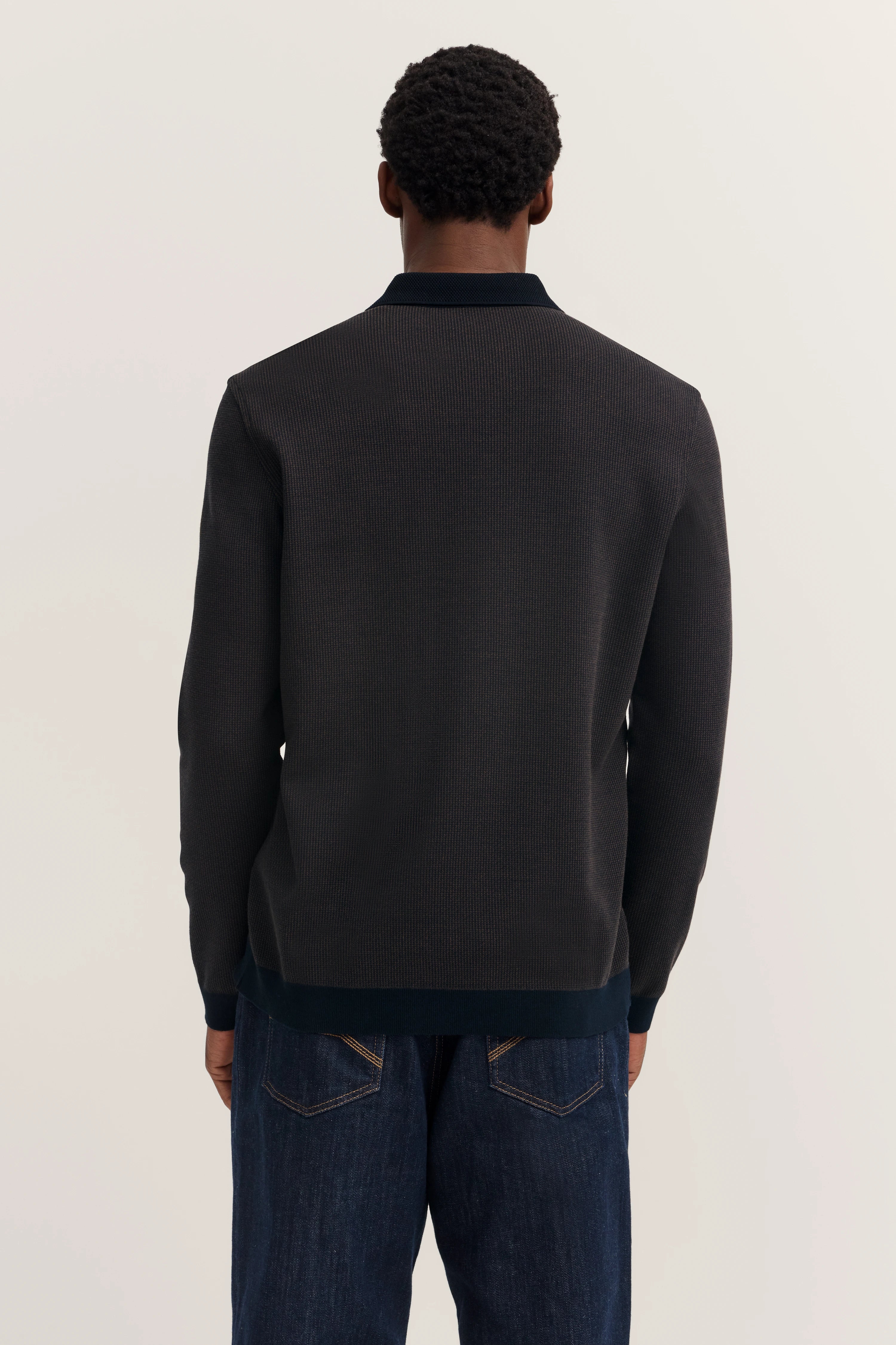 Black bugatti sweater, casual back view model, paired with dark jeans.