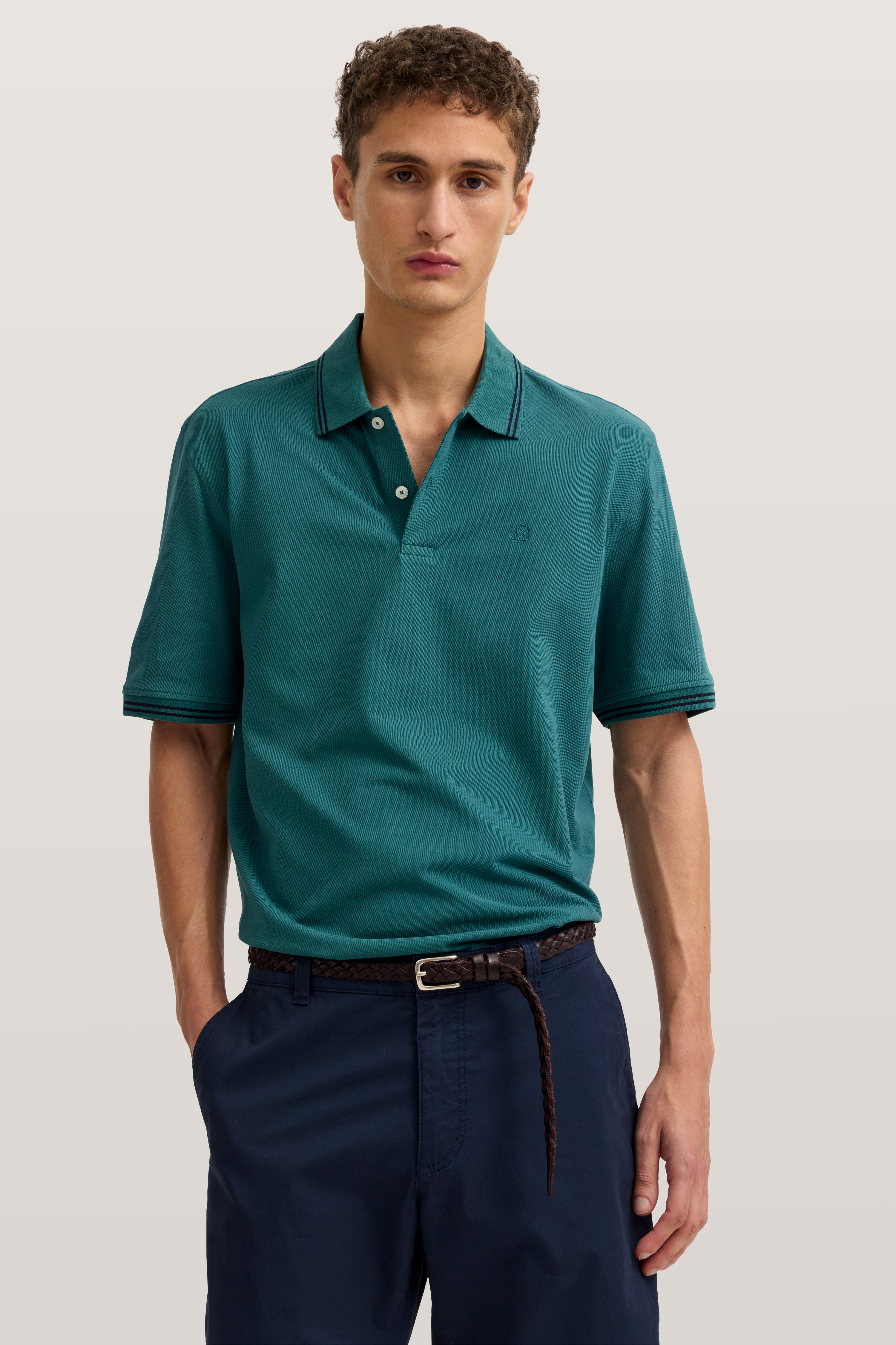 bugatti Polo in Petrol, legeres Modelbild, Hände in Hosentaschen, blaue Hose.