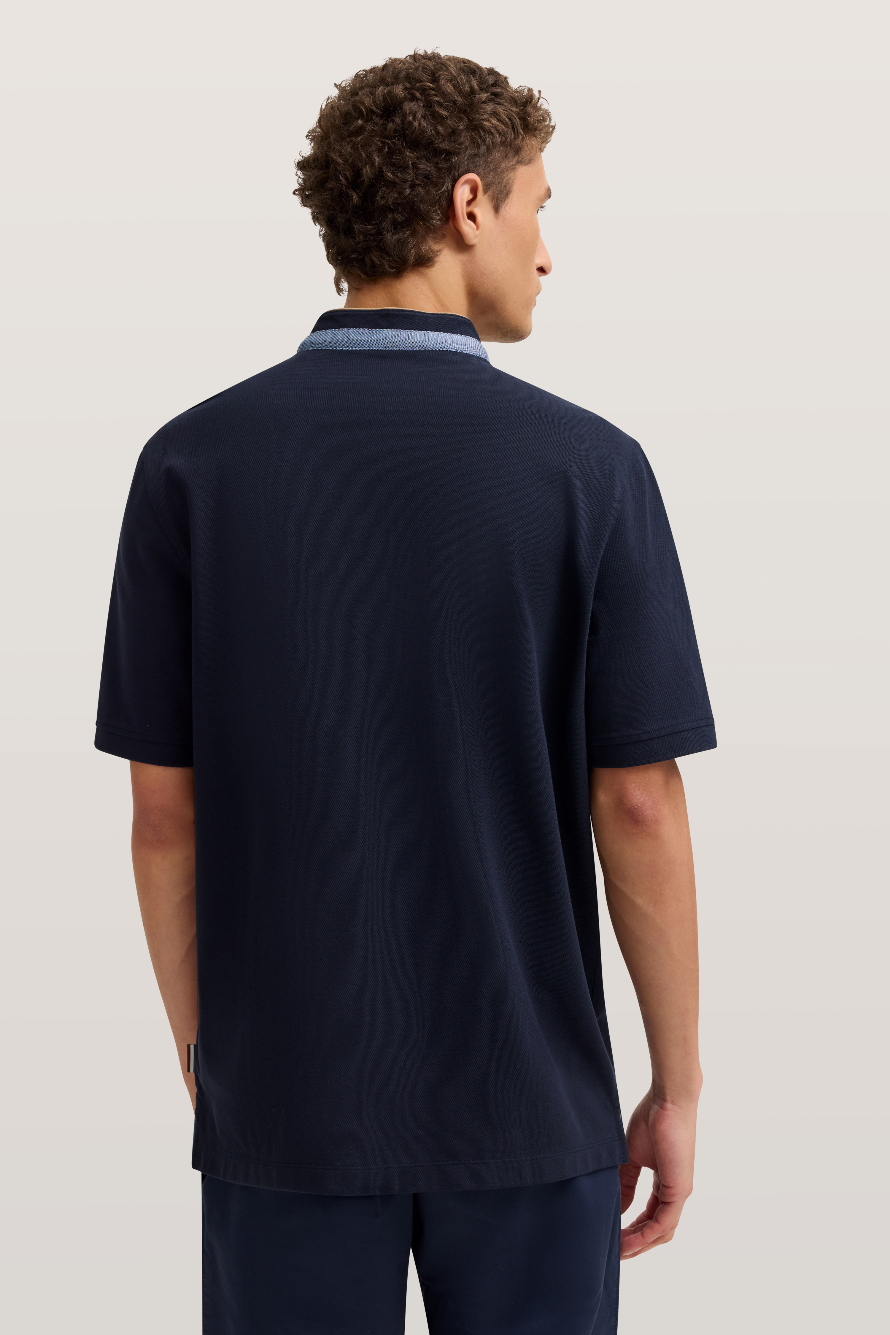 Navy Poloshirt von bugatti, Rückansicht. Lässig, schlichtes Design. Modelbild mit entspanntem Posing.
