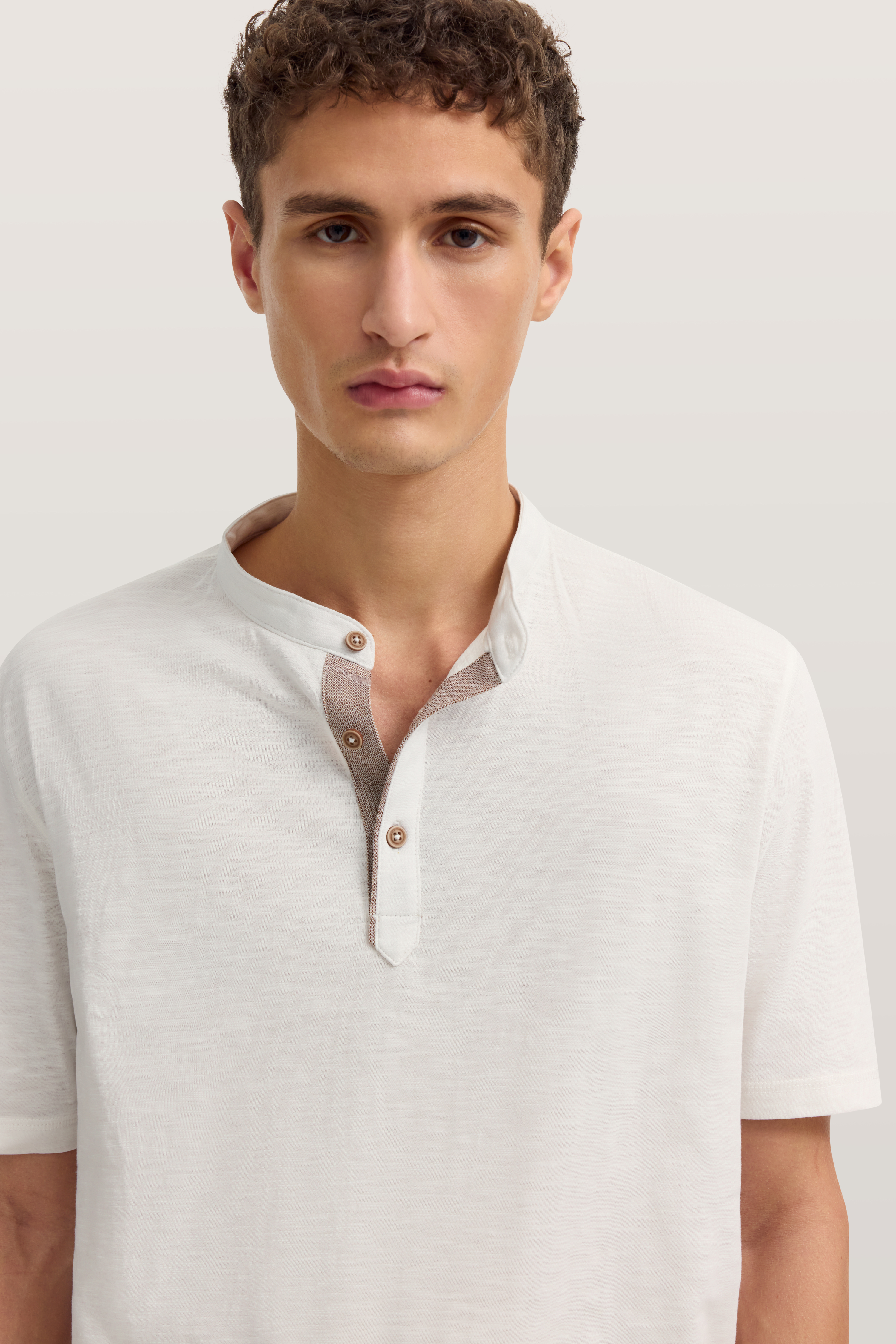 Weißes bugatti Henley-Shirt, Modelbild, entspannter Blick.