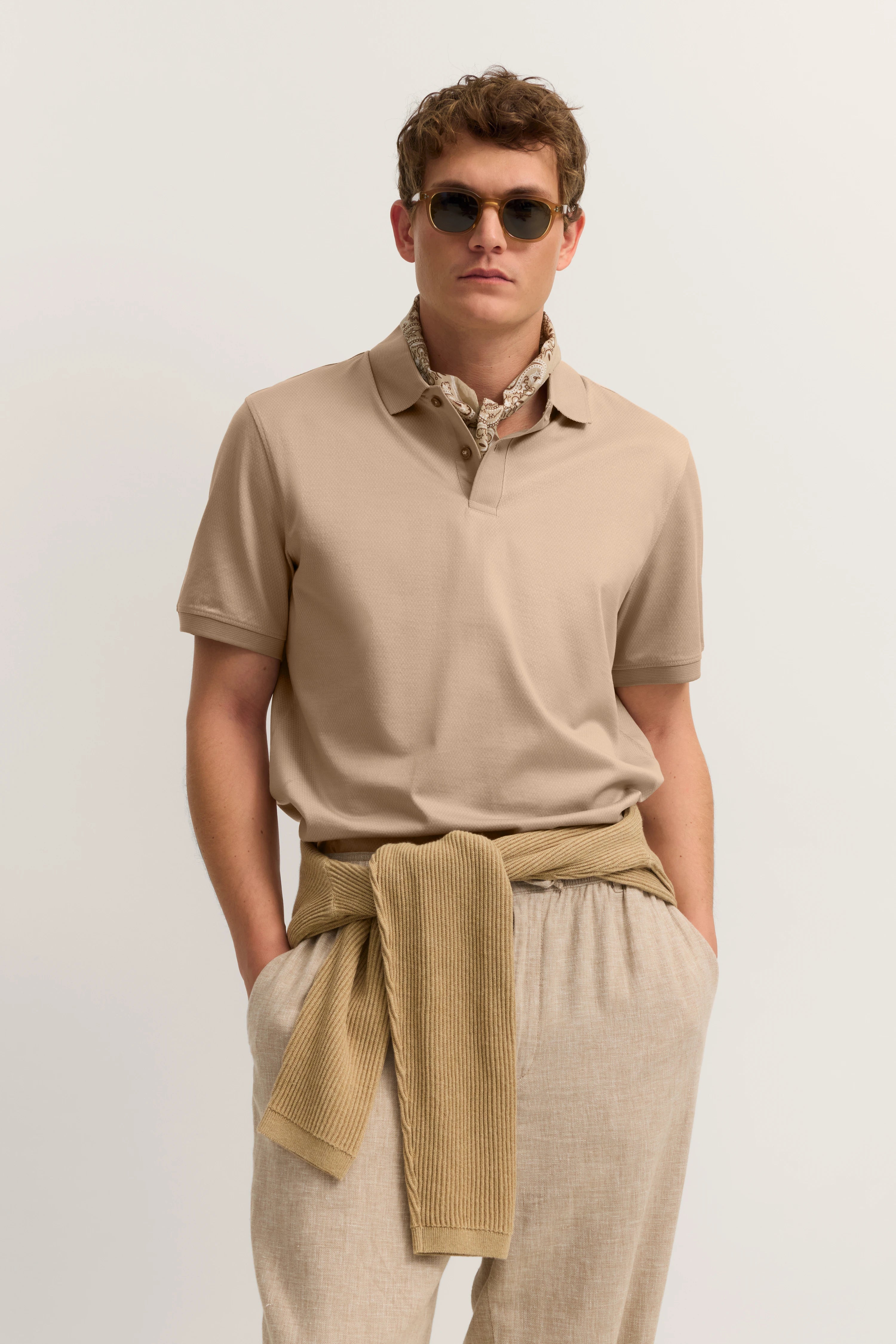 Beiges Polo, beige Hose, Schal, Pullover um Hüfte
