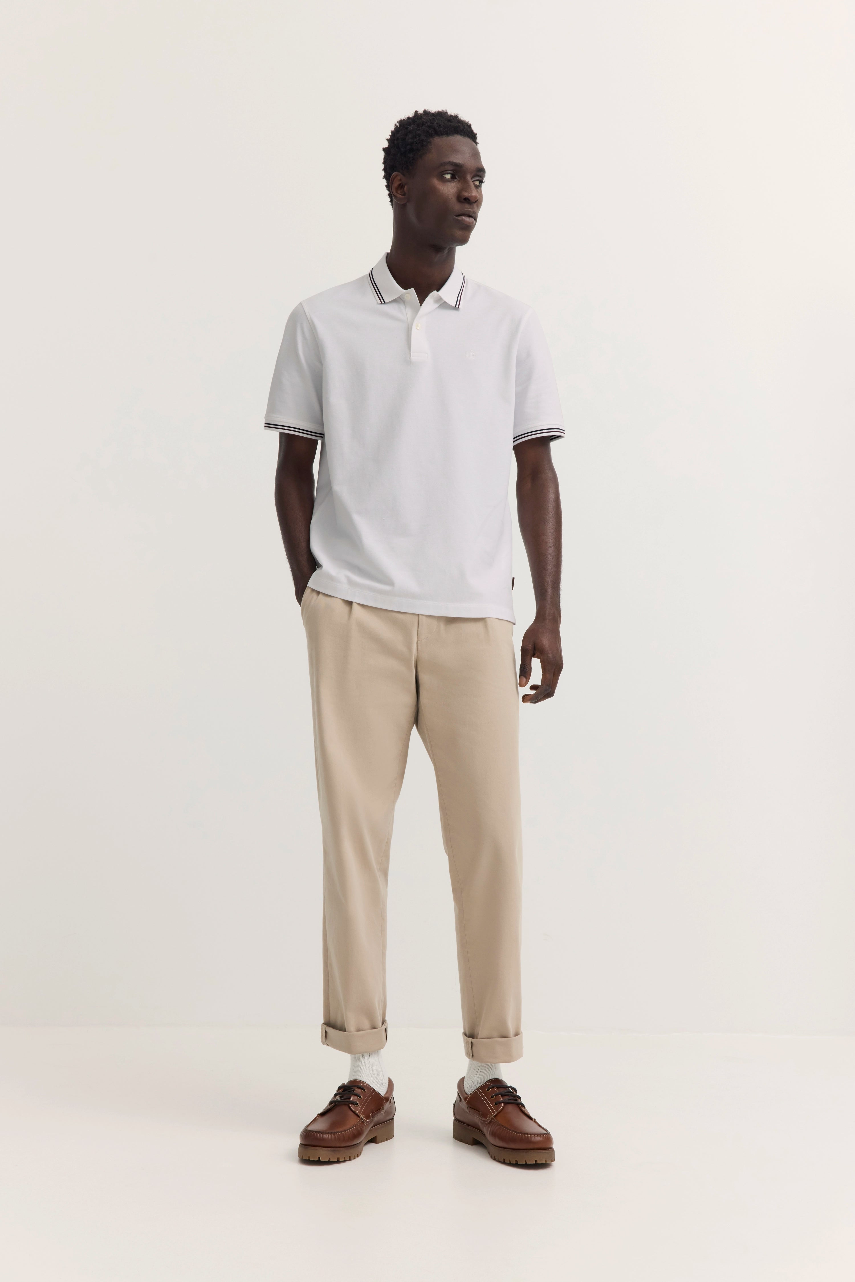 Weiße bugatti Poloshirt auf Model, Büstenbild, klassisch mit gestreiftem Kragen.