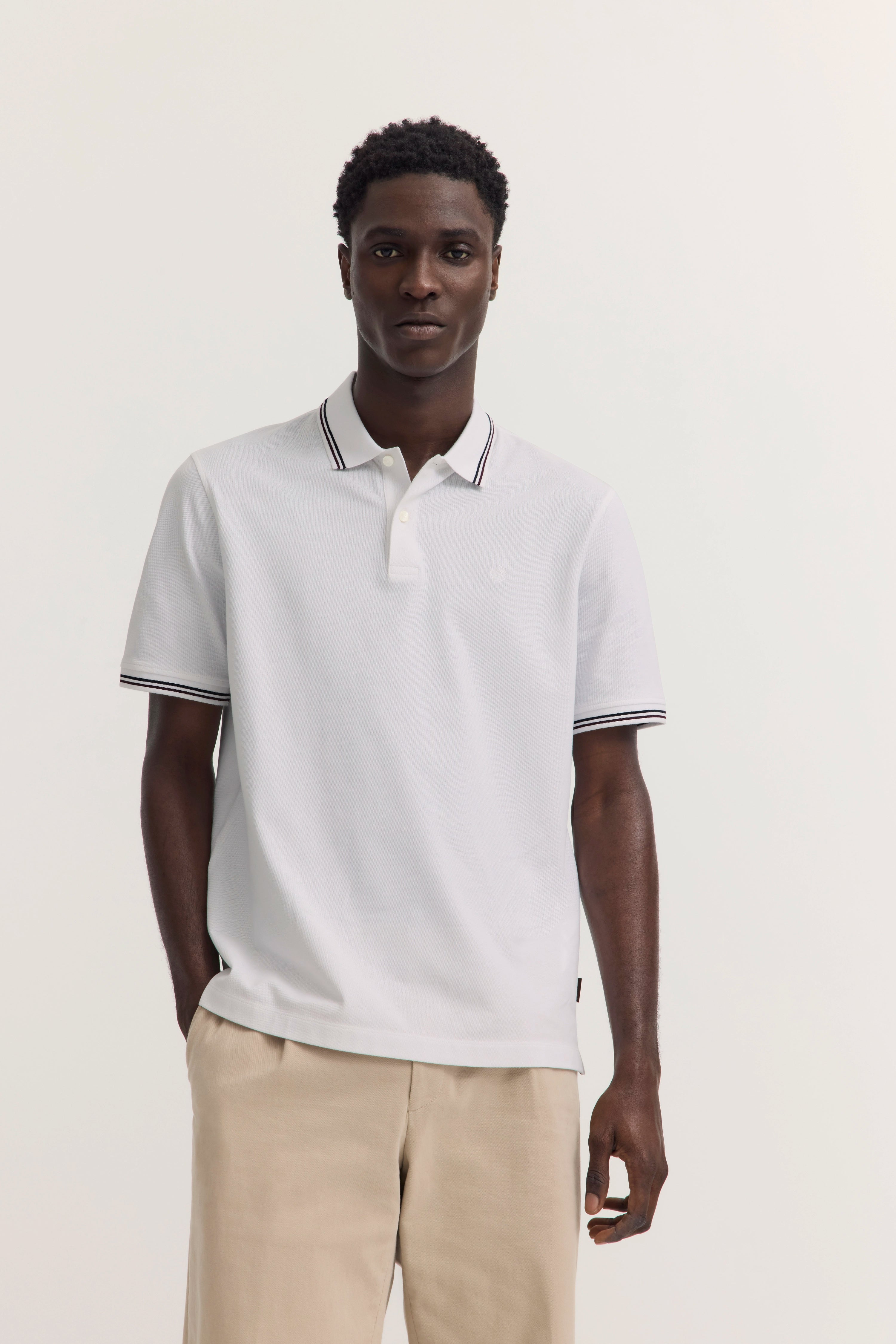 Weißes Polohemd mit schwarzen Streifen, beige Hose
