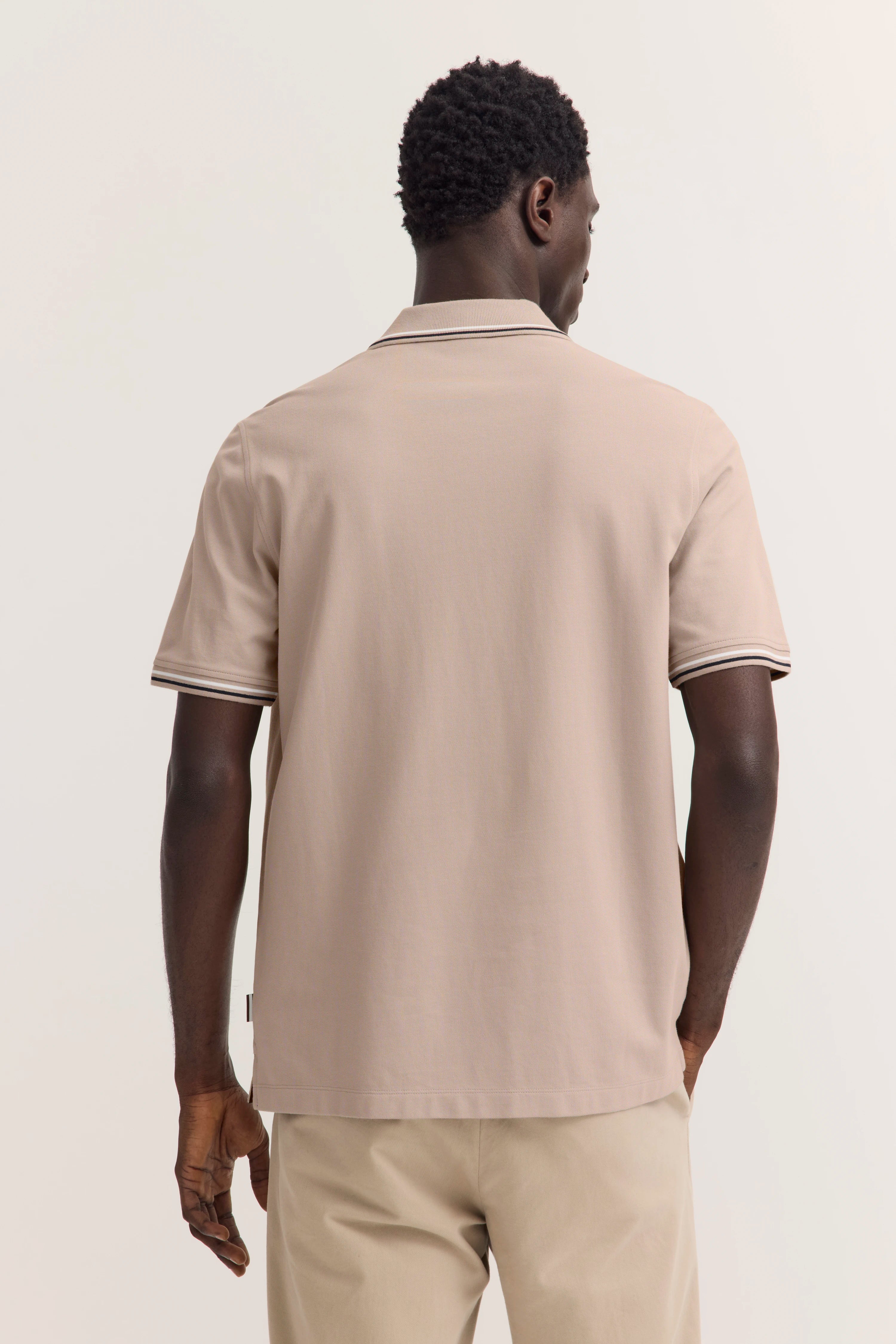 Beiger Polo von bugatti, Rückansicht, legeres Modelbild, Stehpose, klassische Eleganz.