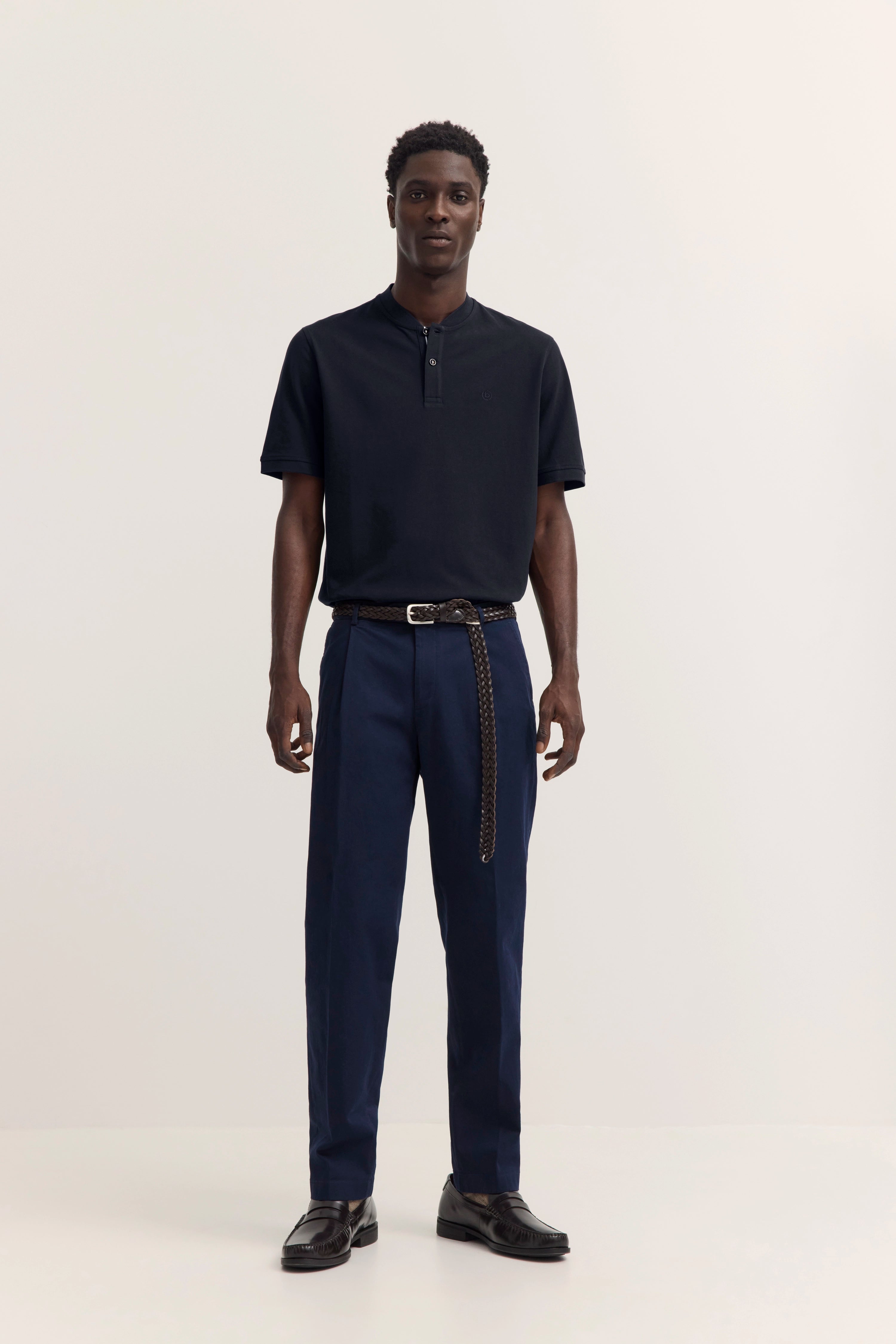 Schwarzes Polo, blaue Hose, geflochtener Gürtel