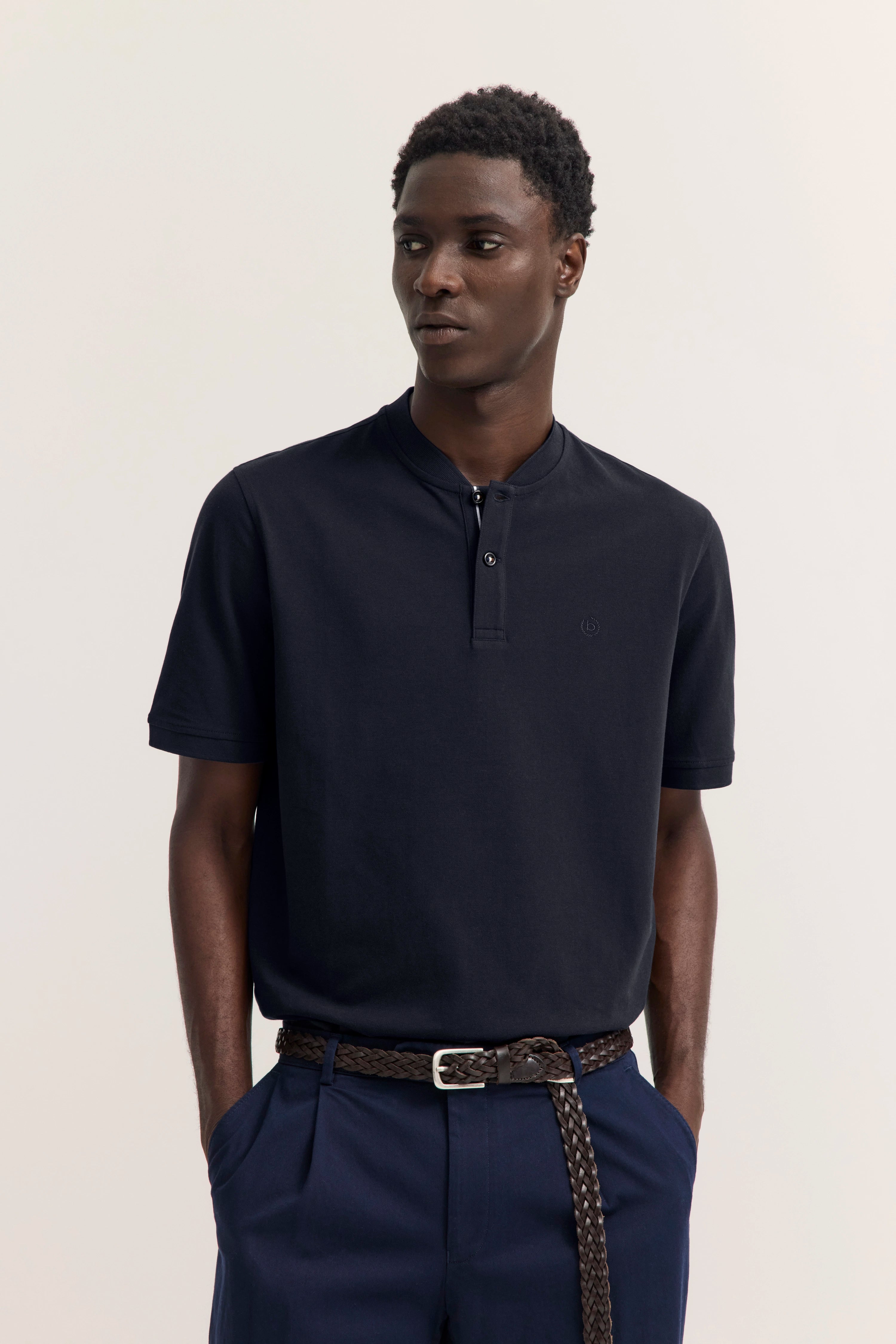 Model in dunkelblauem bugatti Polo und Hose, legeres Posing, stilvoll und elegant.