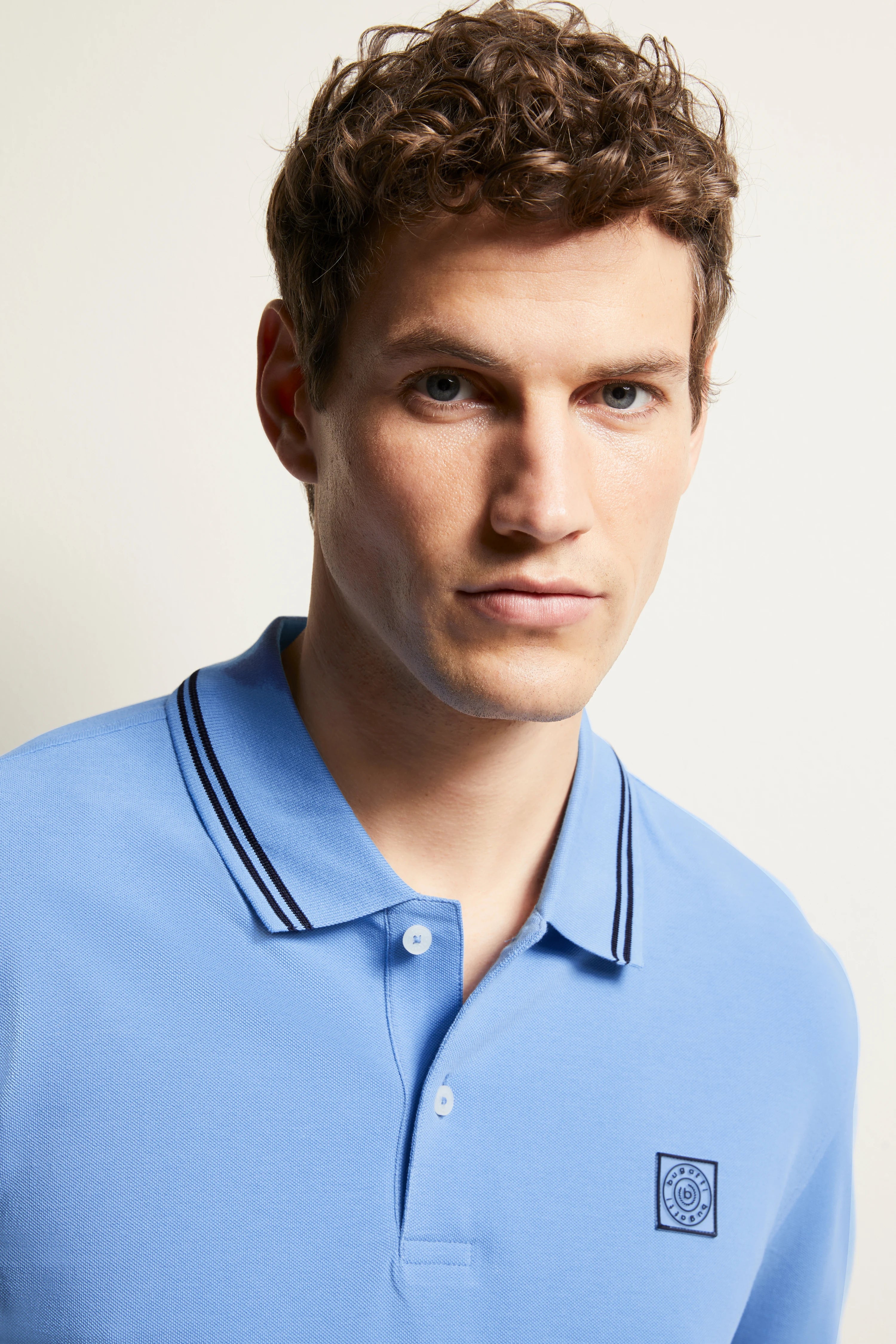 Blue bugatti polo shirt with embroidered logo, model image, relaxed look.
