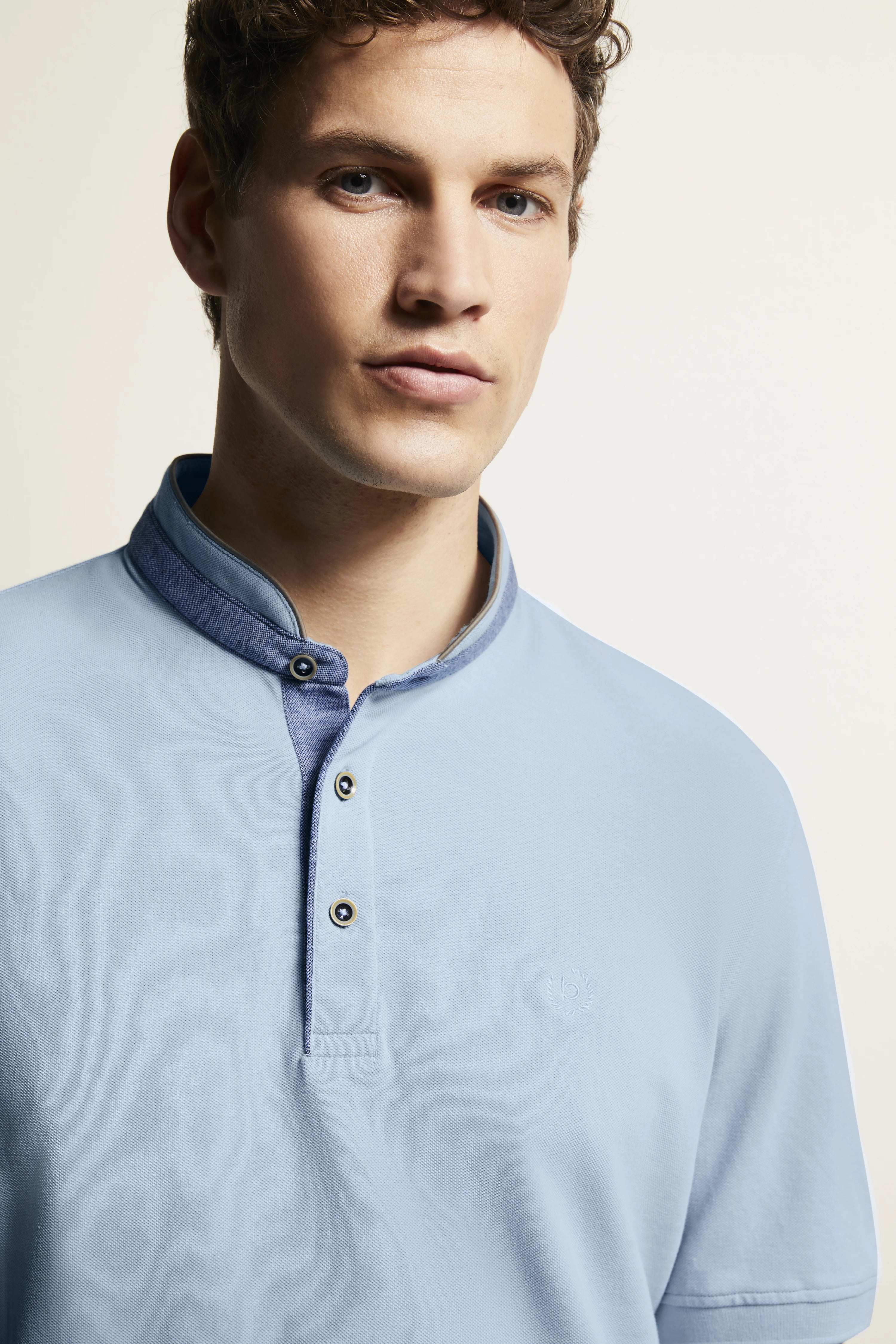 Büstenbild eines Mannes im hellblauen bugatti-Poloshirt mit Stehkragen und Knopfleiste.
