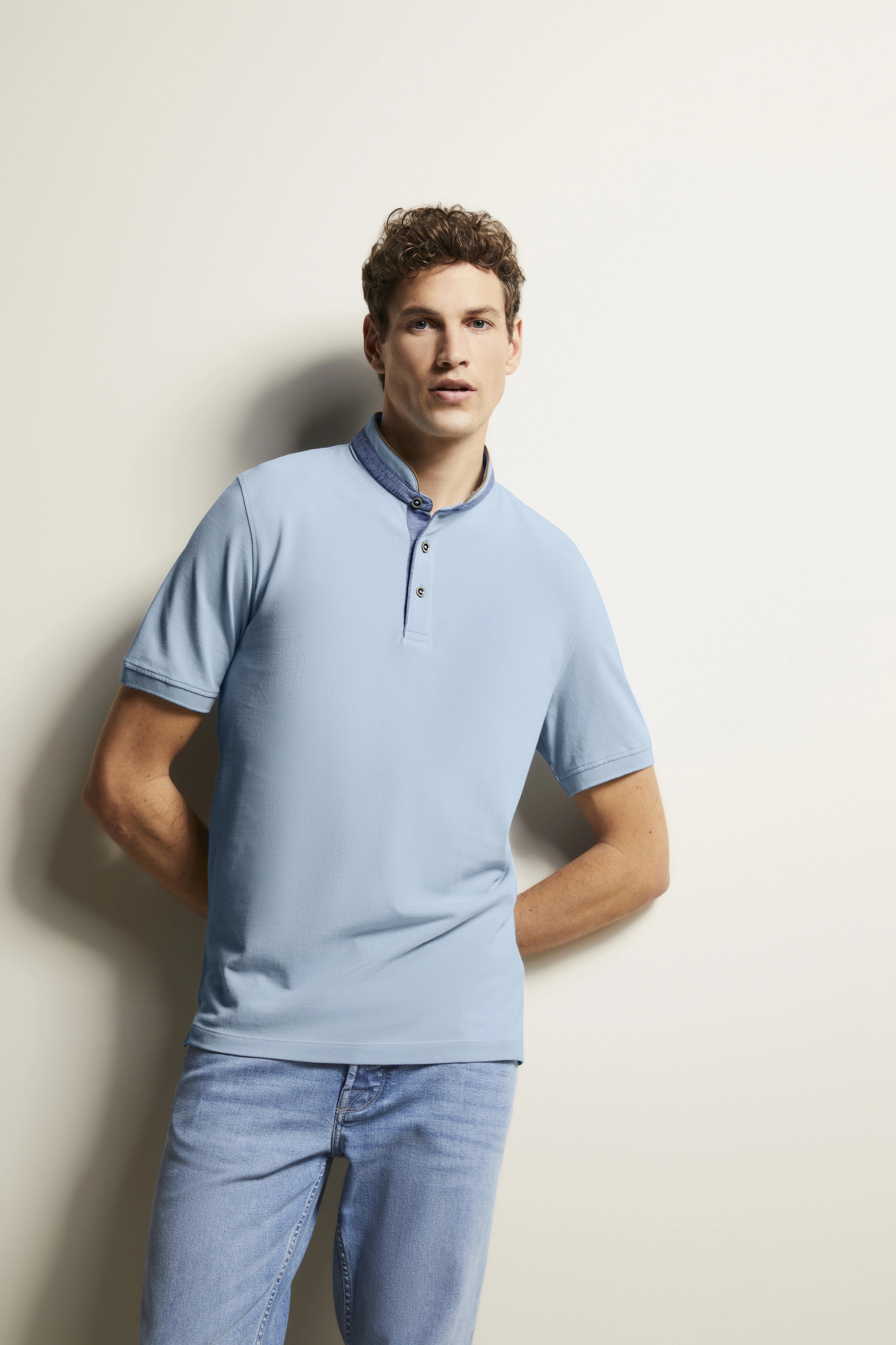 Model in hellem bugatti Polo und Jeans, entspannte Pose, stilvoller Look.