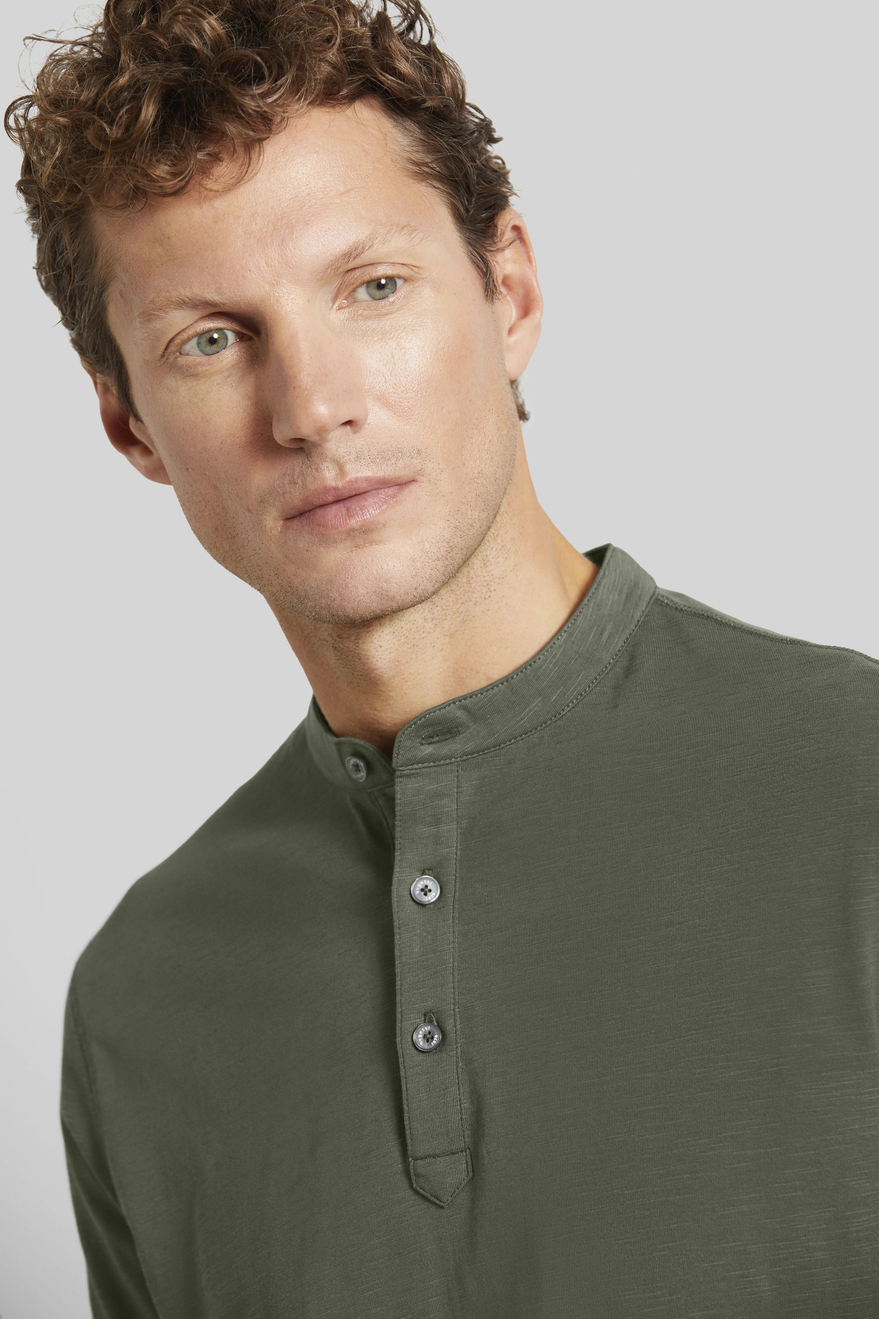 Borstbeeld van een man in een olijfgroen Henley-shirt van bugatti, ontspannen en stijlvol.