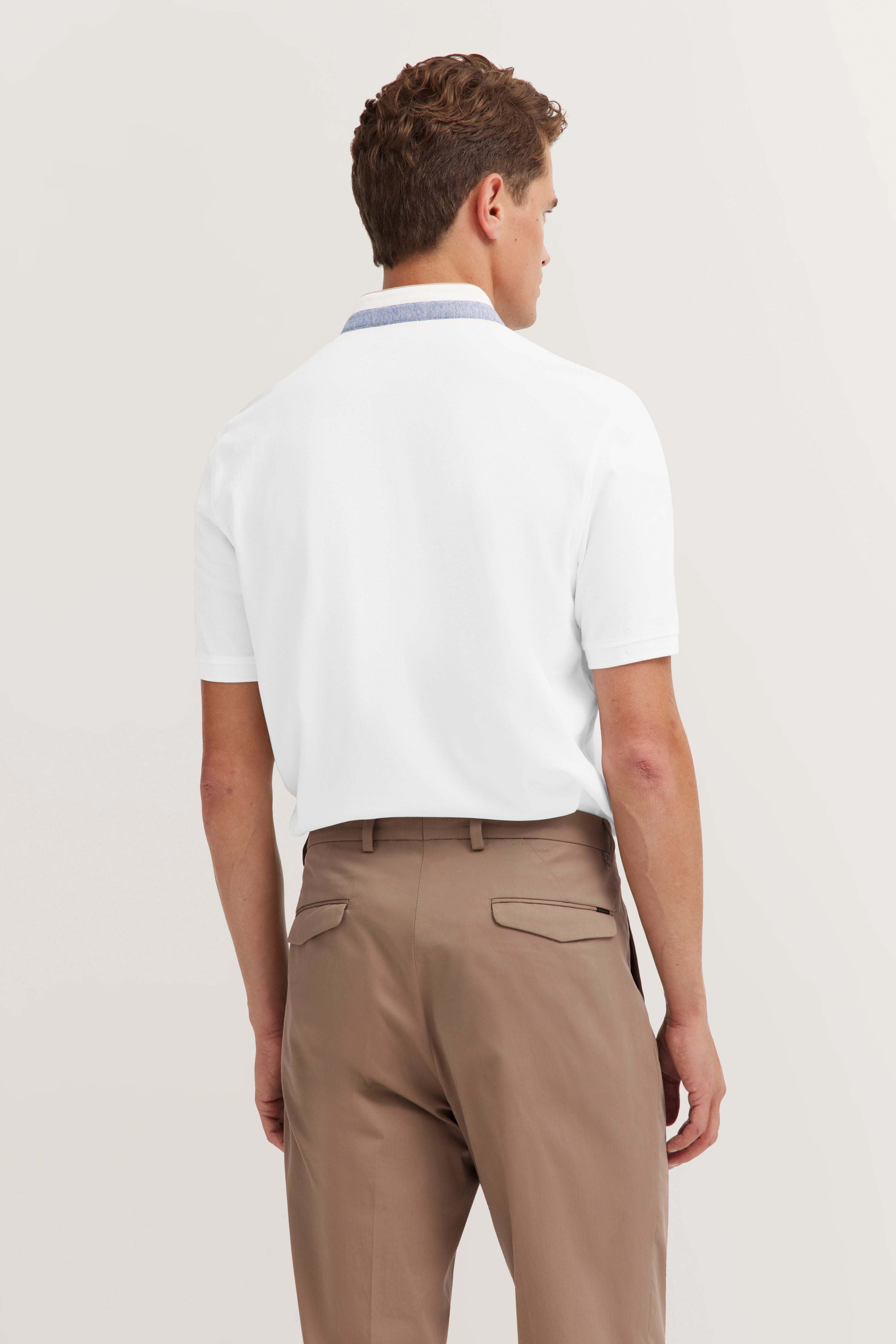 White bugatti polo shirt and beige chinos, rear view, relaxed pose.