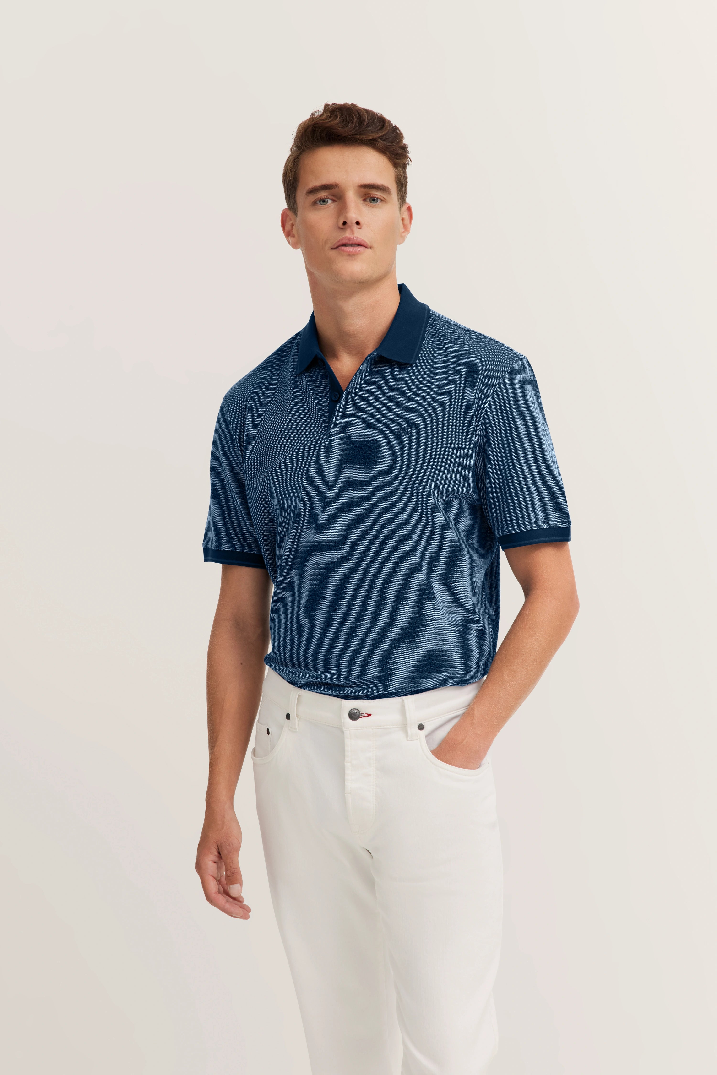 Model wearing blue polo shirt and white jeans, relaxed pose, bugatti style and sophistication.