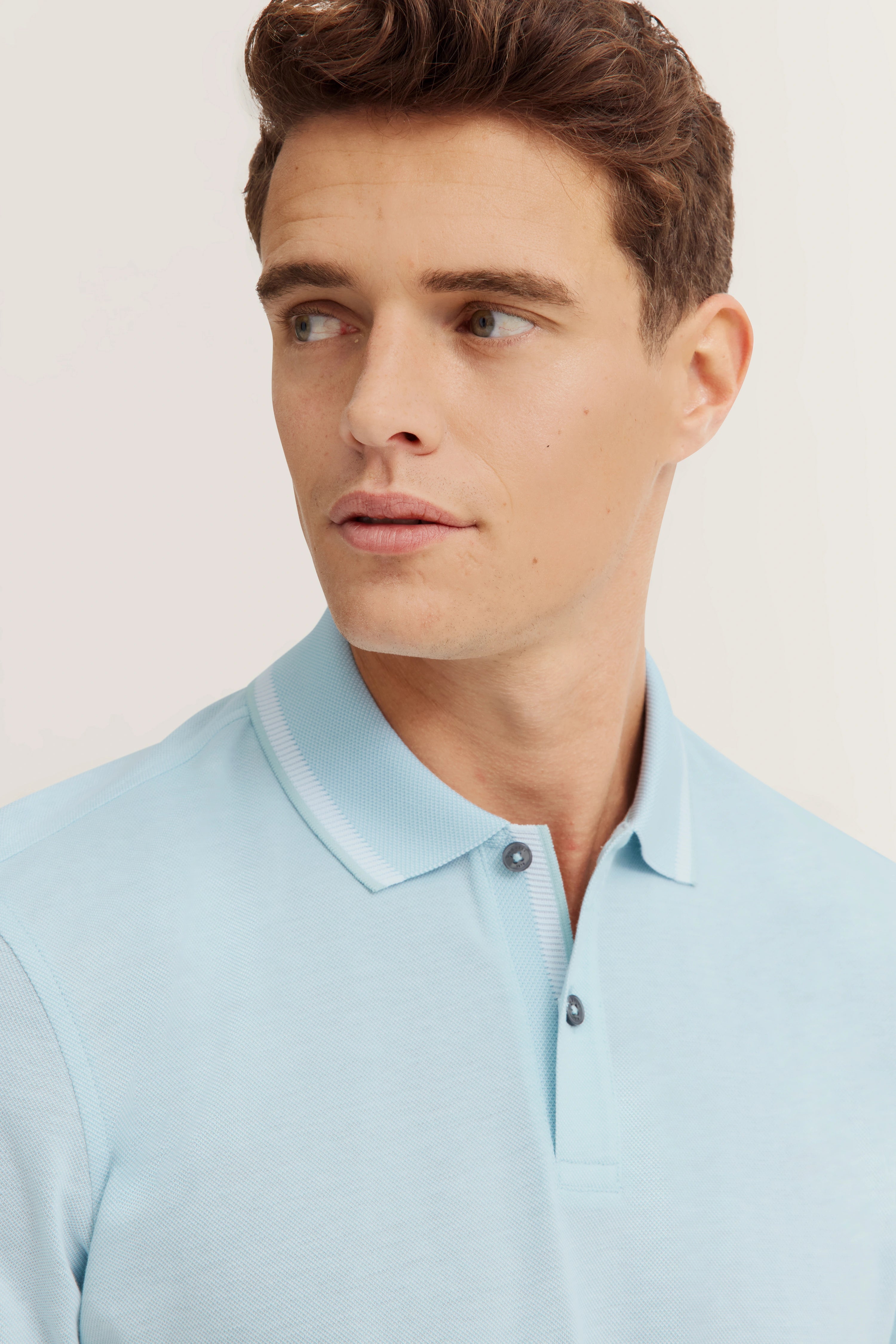 bugatti model image, light blue polo shirt, relaxed pose, timeless elegance.