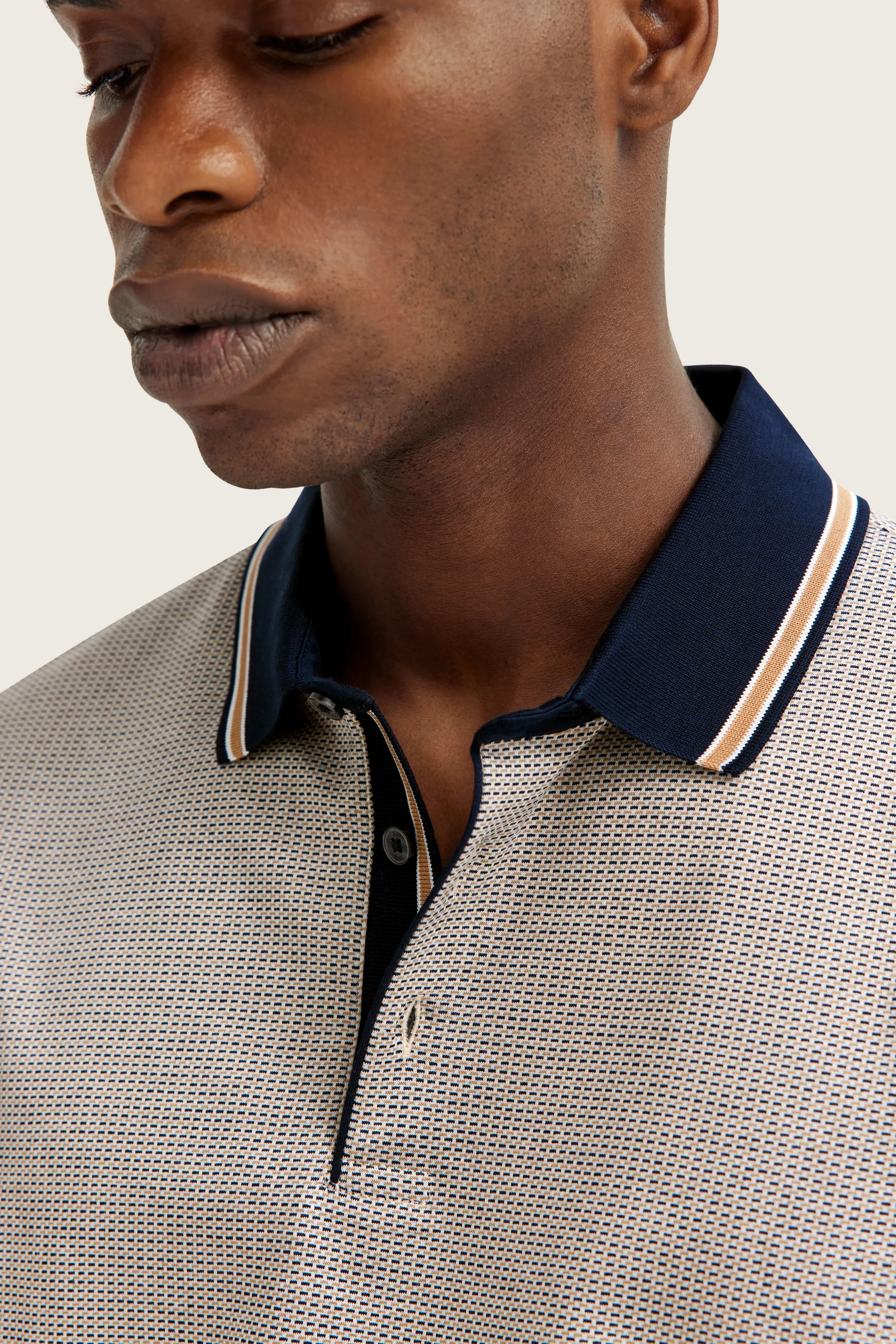 bugatti men's polo shirt, beige with blue pattern, bust view, subtle design, stylish and elegant.