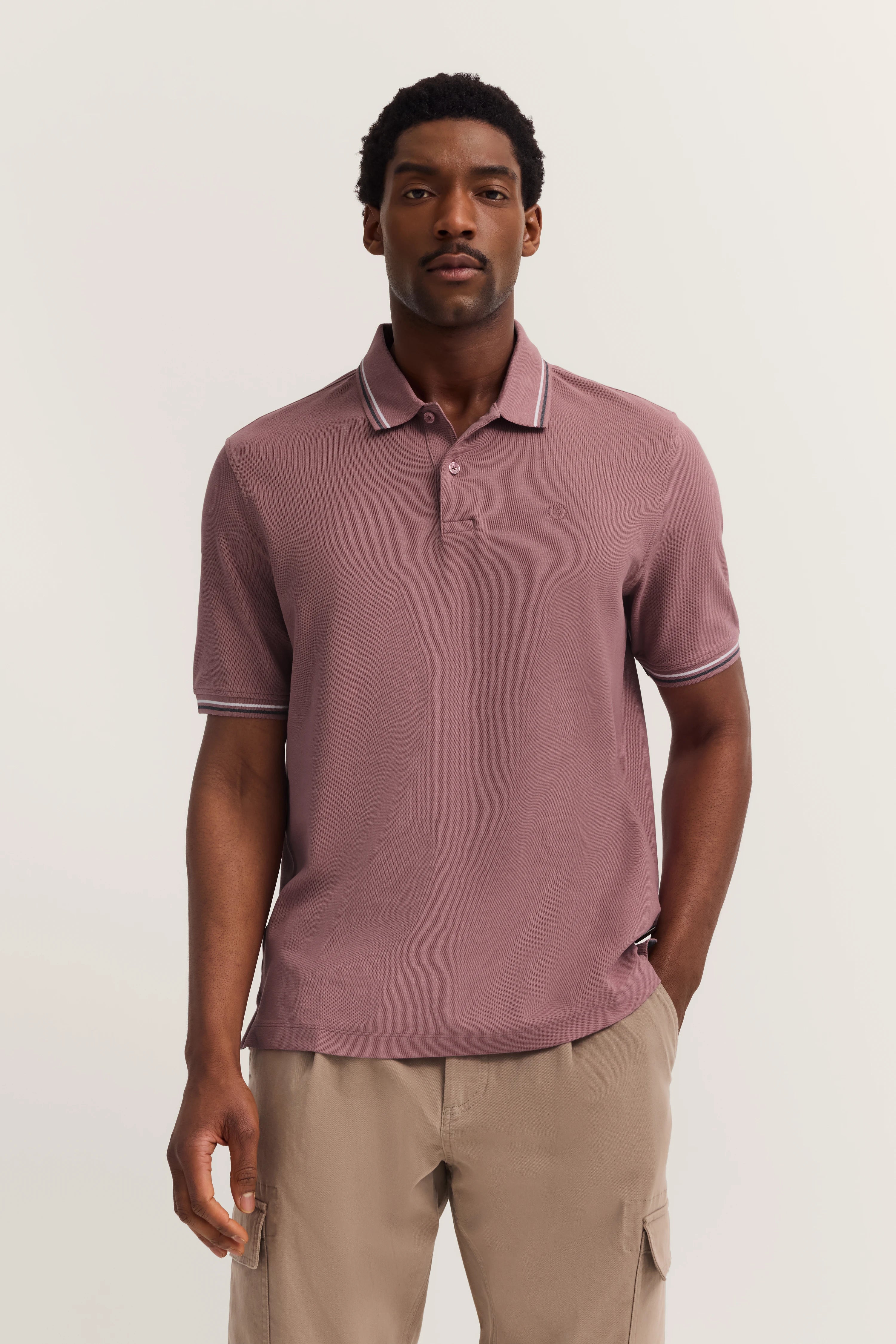 bugatti mauve polo with fine collar and sleeve stripes, model in relaxed pose.