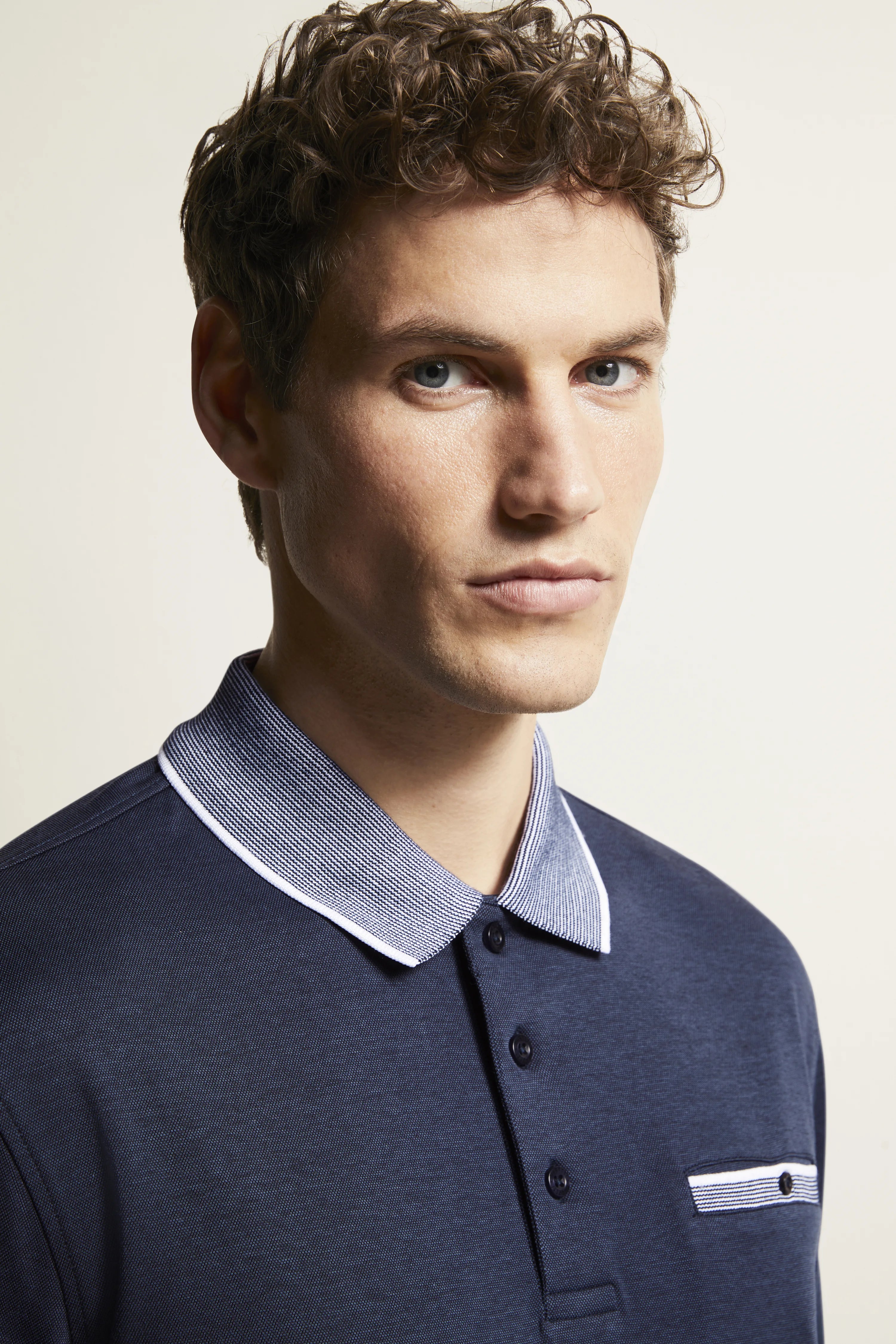 bugatti dark blue polo shirt with white collar, model in casual pose, embodies Italian-inspired elegance and style.