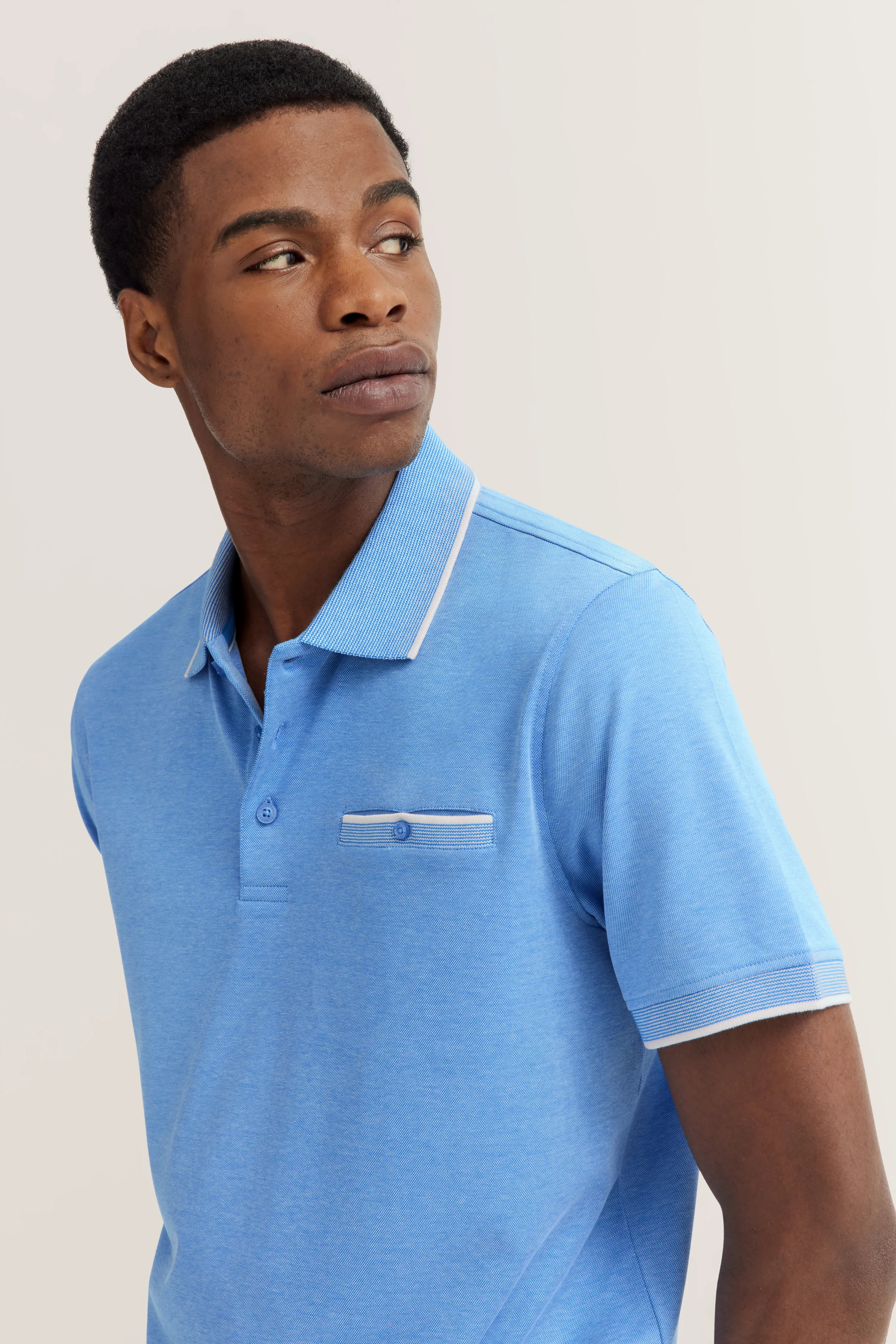 Blue bugatti polo shirt on model, casual pose, chest pocket, contrast details.