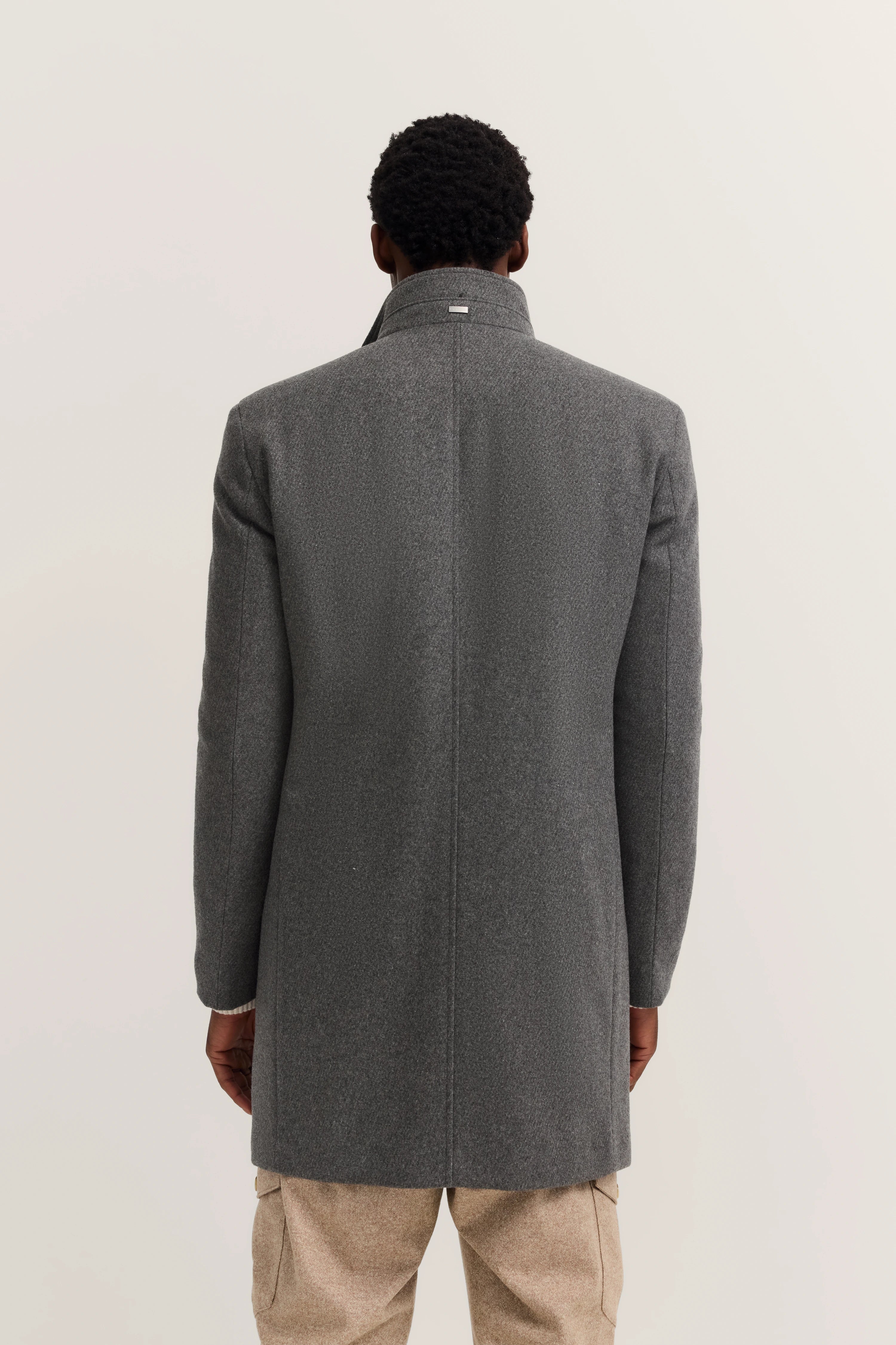 Grauer bugatti Mantel, Rückenansicht, Model trägt beige Hose, klassisch elegant.