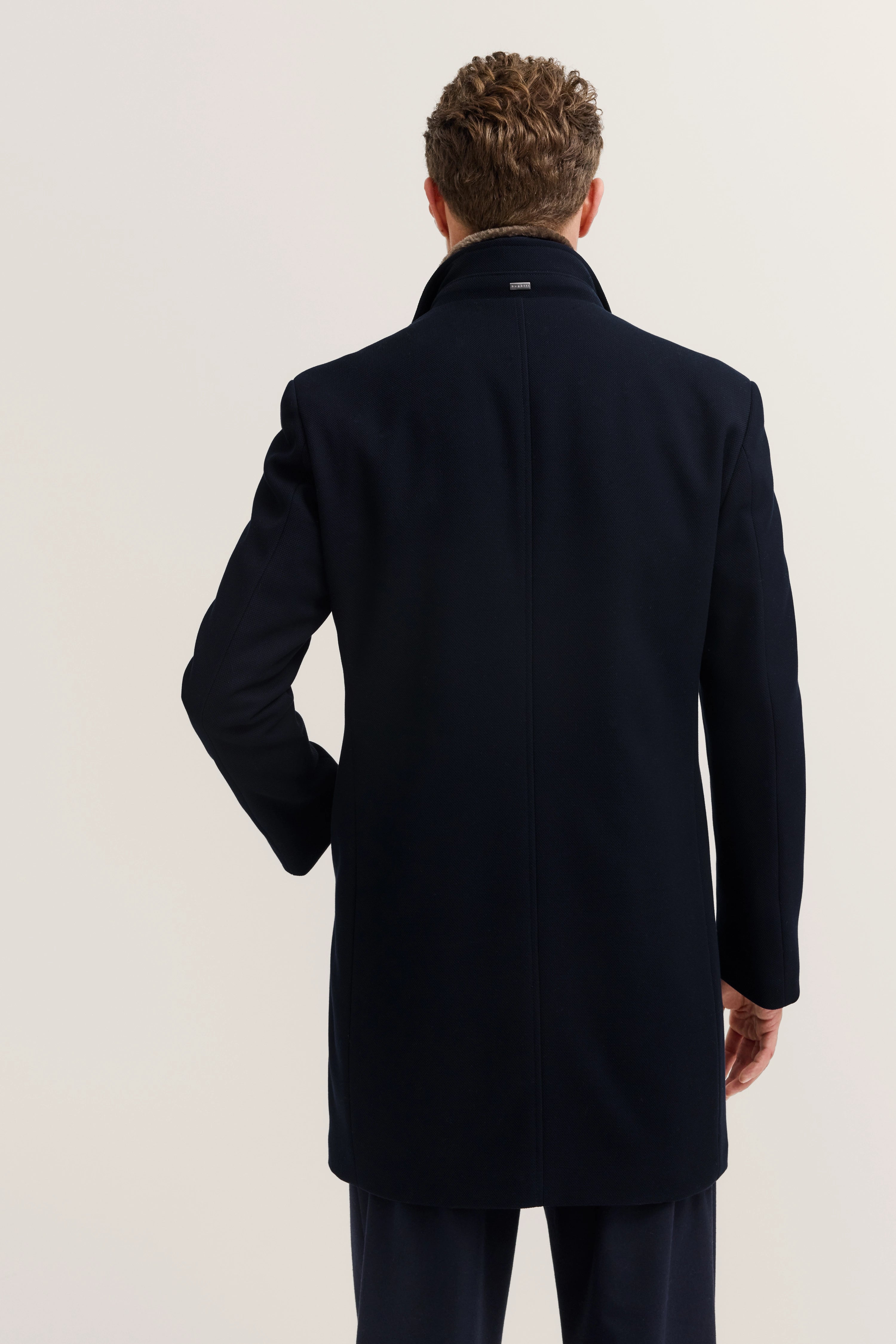 Dunkelblauer bugatti Mantel, Rückansicht, elegantes Design, hochwertiger Stoff, legeres Modelbild.