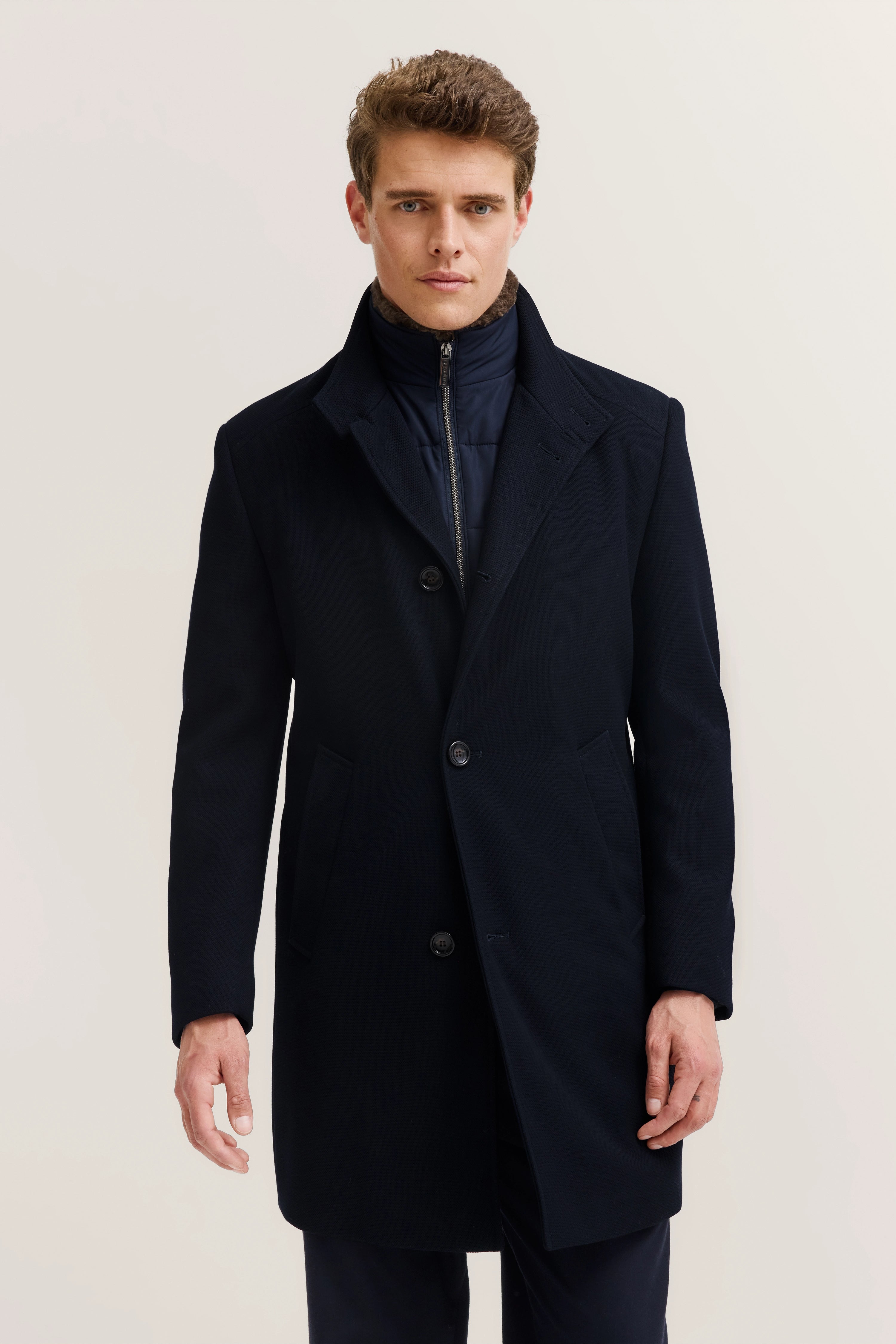 Navy blauer bugatti Mantel auf Modelbild, klassisch geschlossen, stilvoller Ausdruck.