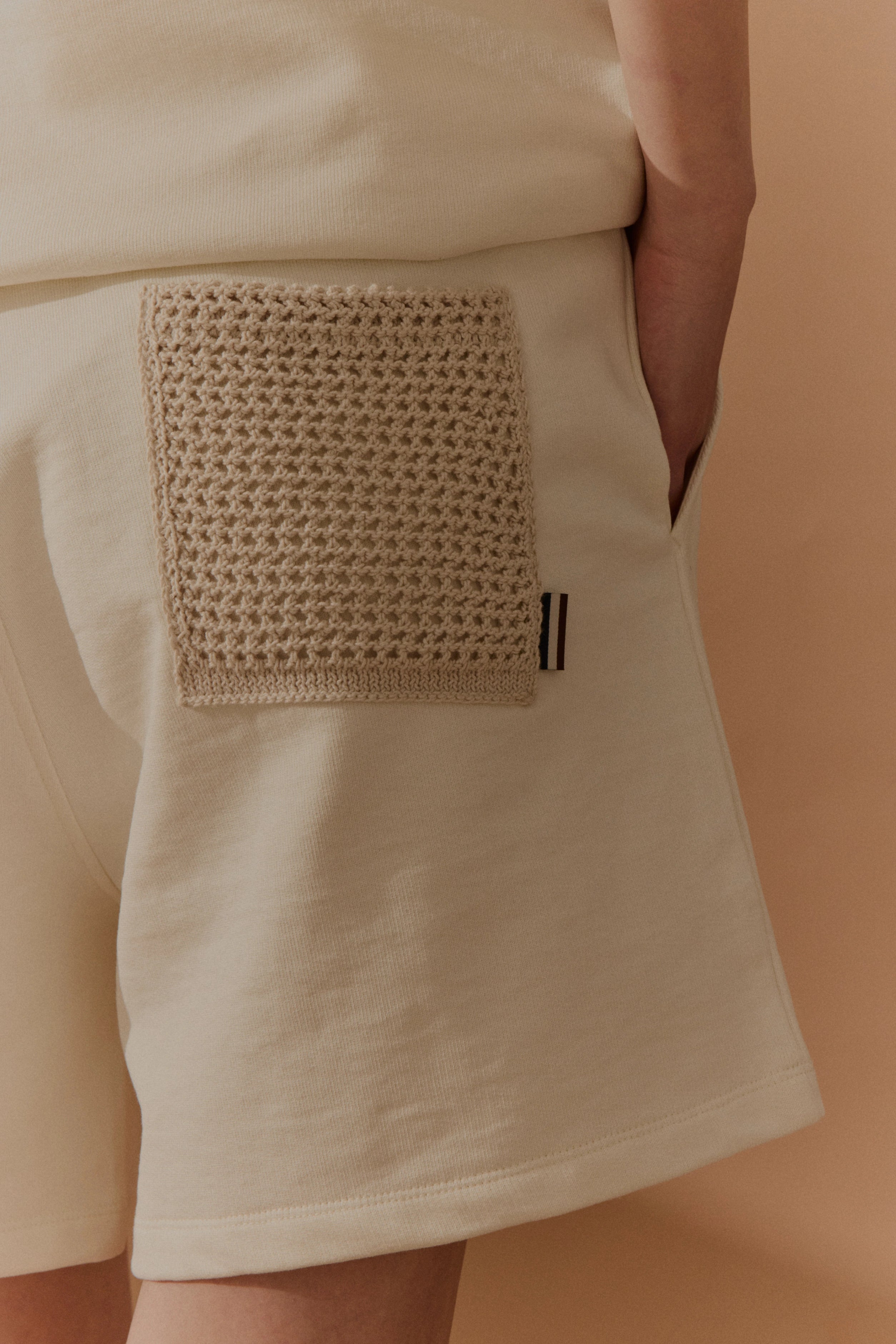 Cremefarbene Shorts mit gehäkeltem Detail, legere Bildaufnahme, bugatti Stil.