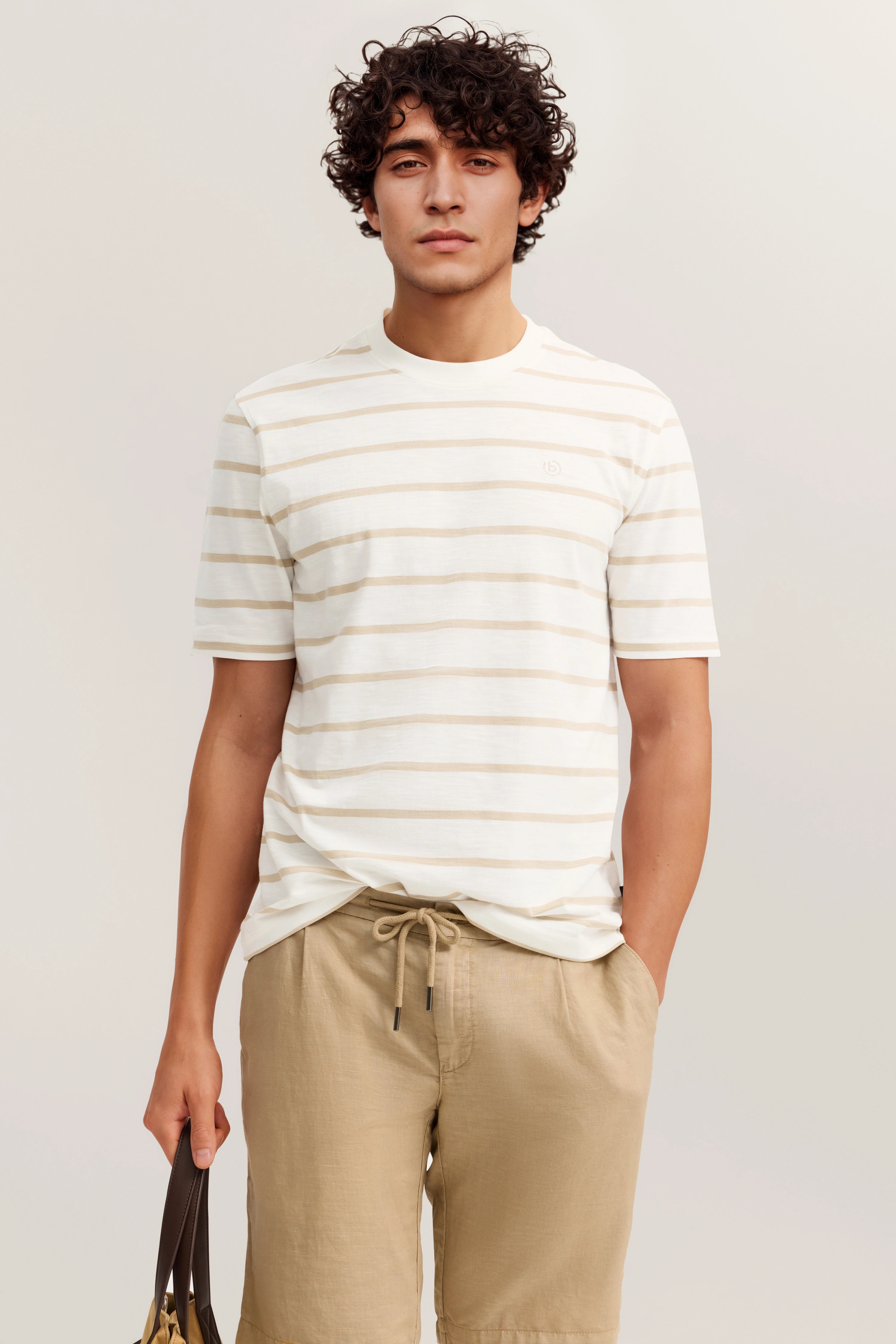 Weiß-beige gestreiftes T-Shirt, beige Shorts, legeres Modelbild, entspanntes Posing, bugatti Stil.