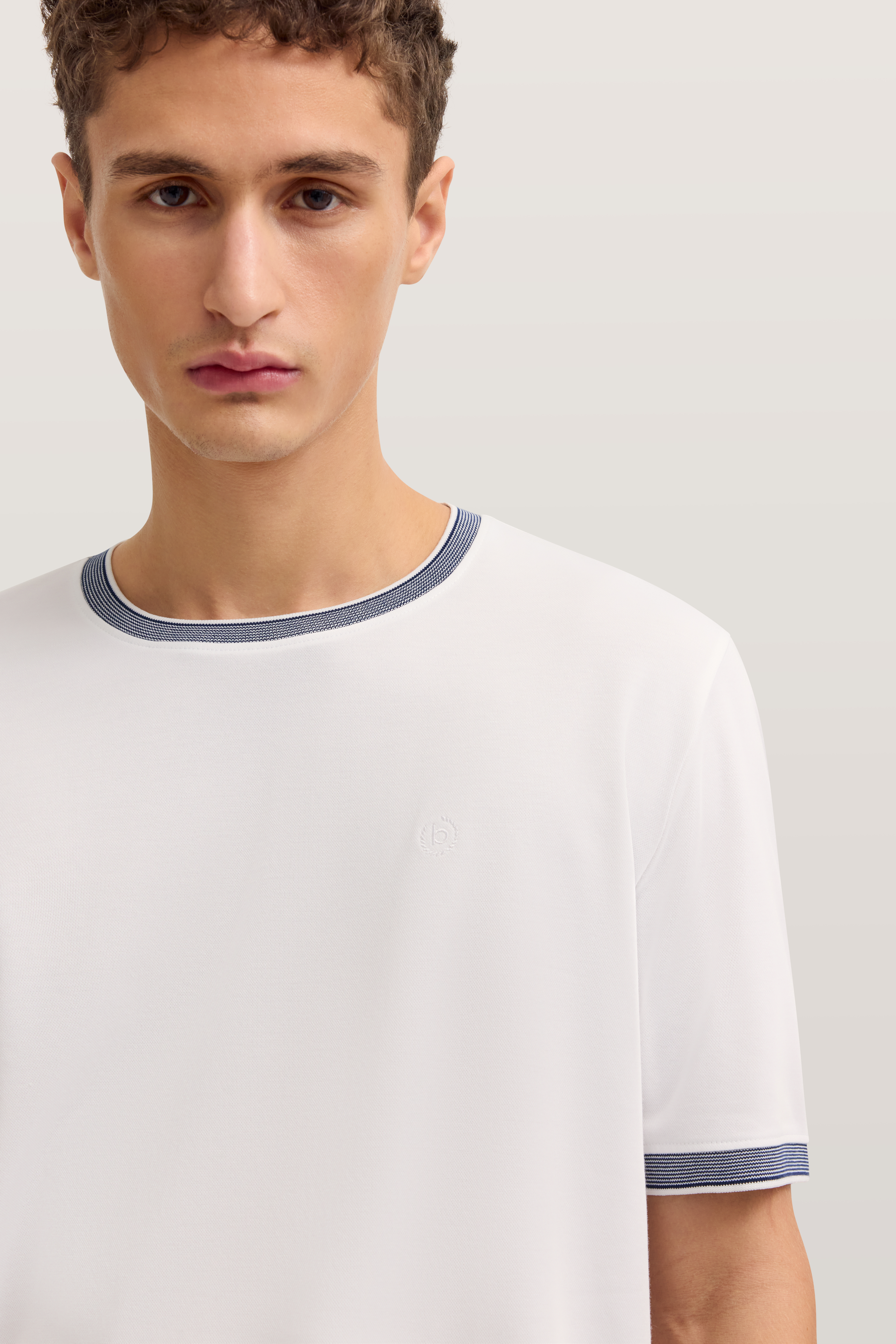 Weißes bugatti T-Shirt mit blauem Kragen und Ärmelrand, Modelbild nah.