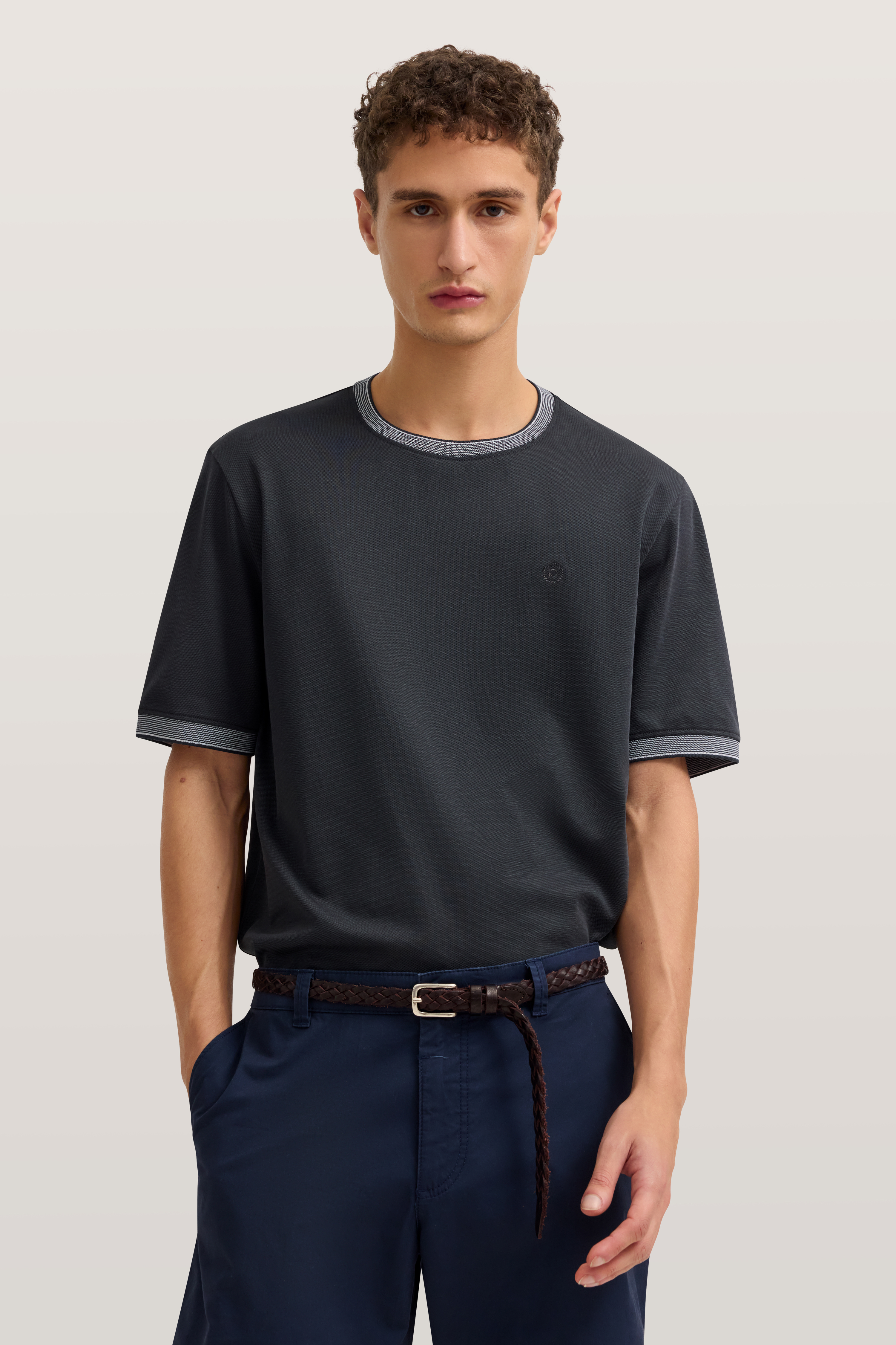Modelbild: Mann in dunkelblauem T-Shirt und blauer Hose, entspanntes Posing.