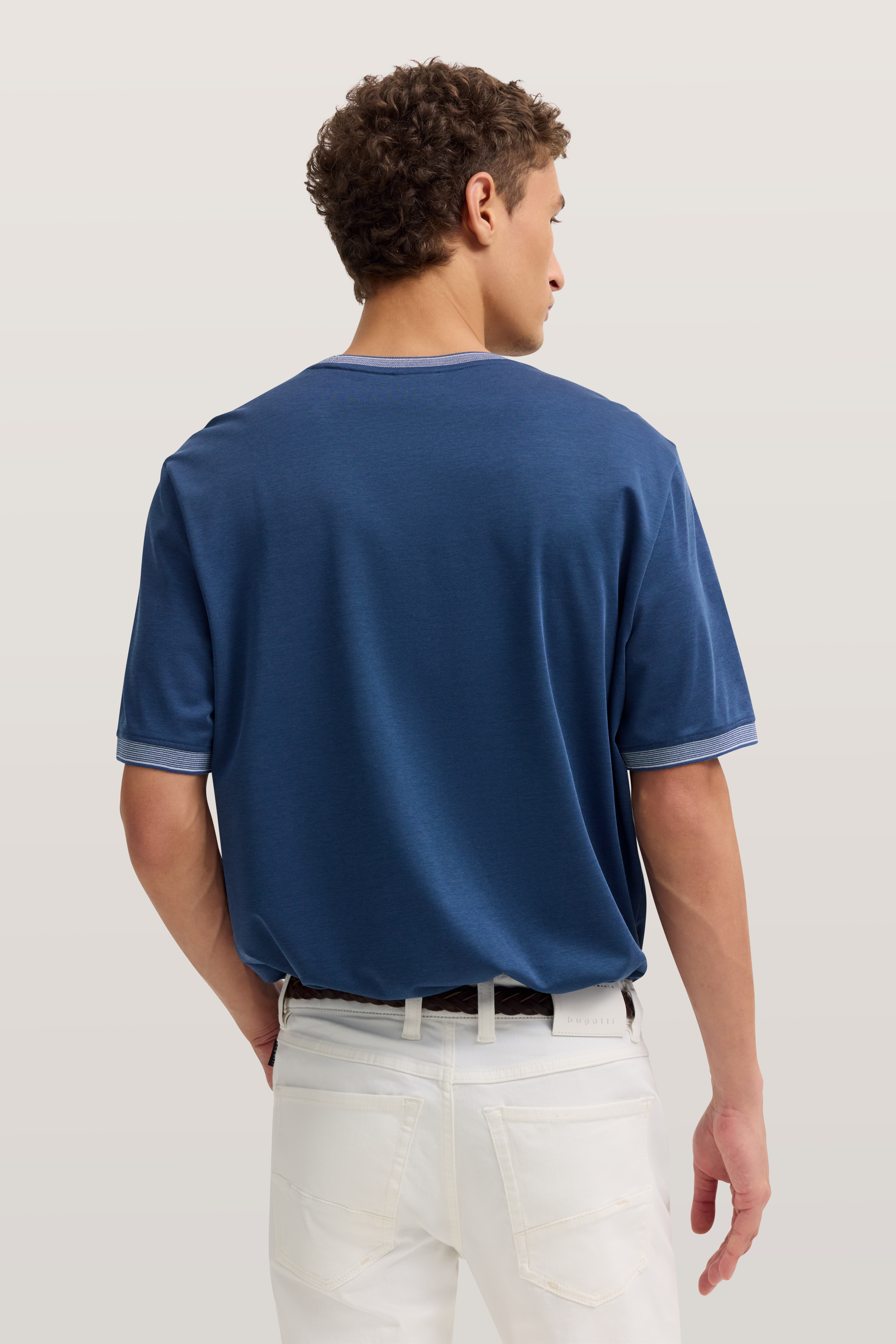 Blaues T-Shirt und weiße Jeans von bugatti, Rückansicht, entspannte Pose.