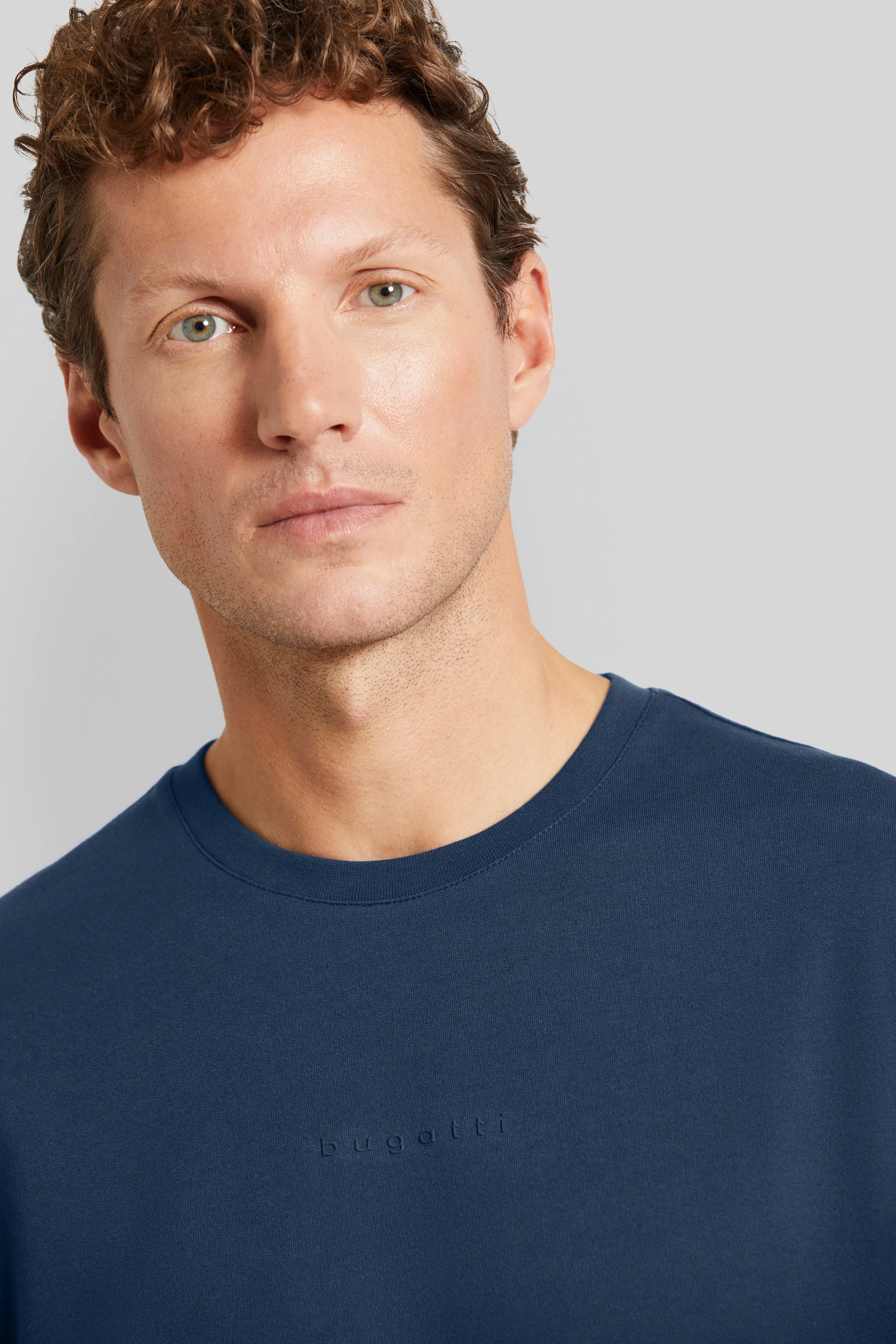 bugatti men's blue T-shirt, model posing relaxed, embodies Italian-inspired elegance and style.