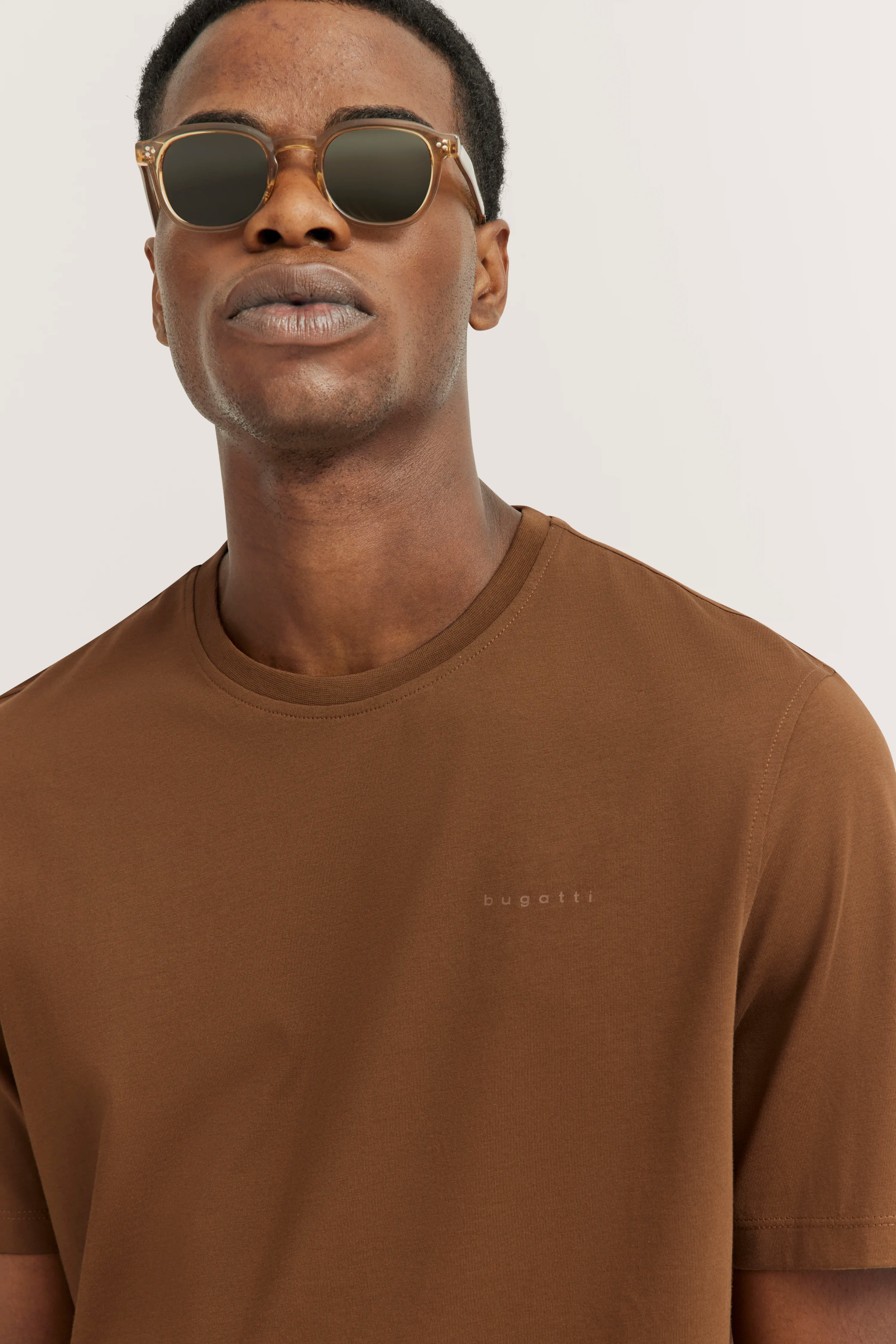 Brown bugatti T-shirt on model, casual portrait with sunglasses, stylish and timeless.