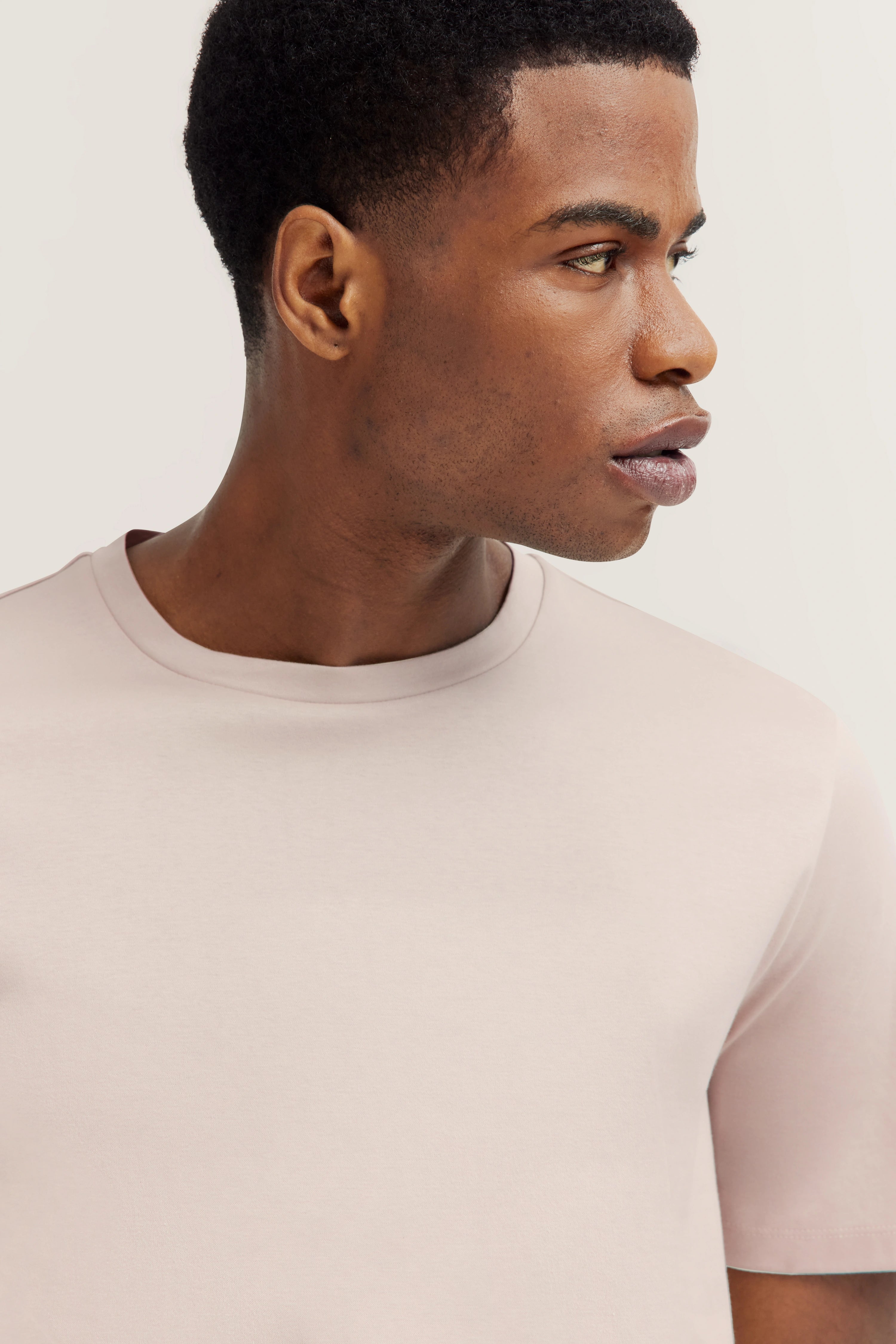 Side profile of a man in a light bugatti T-shirt, embodying refined style and Italian-inspired elegance.