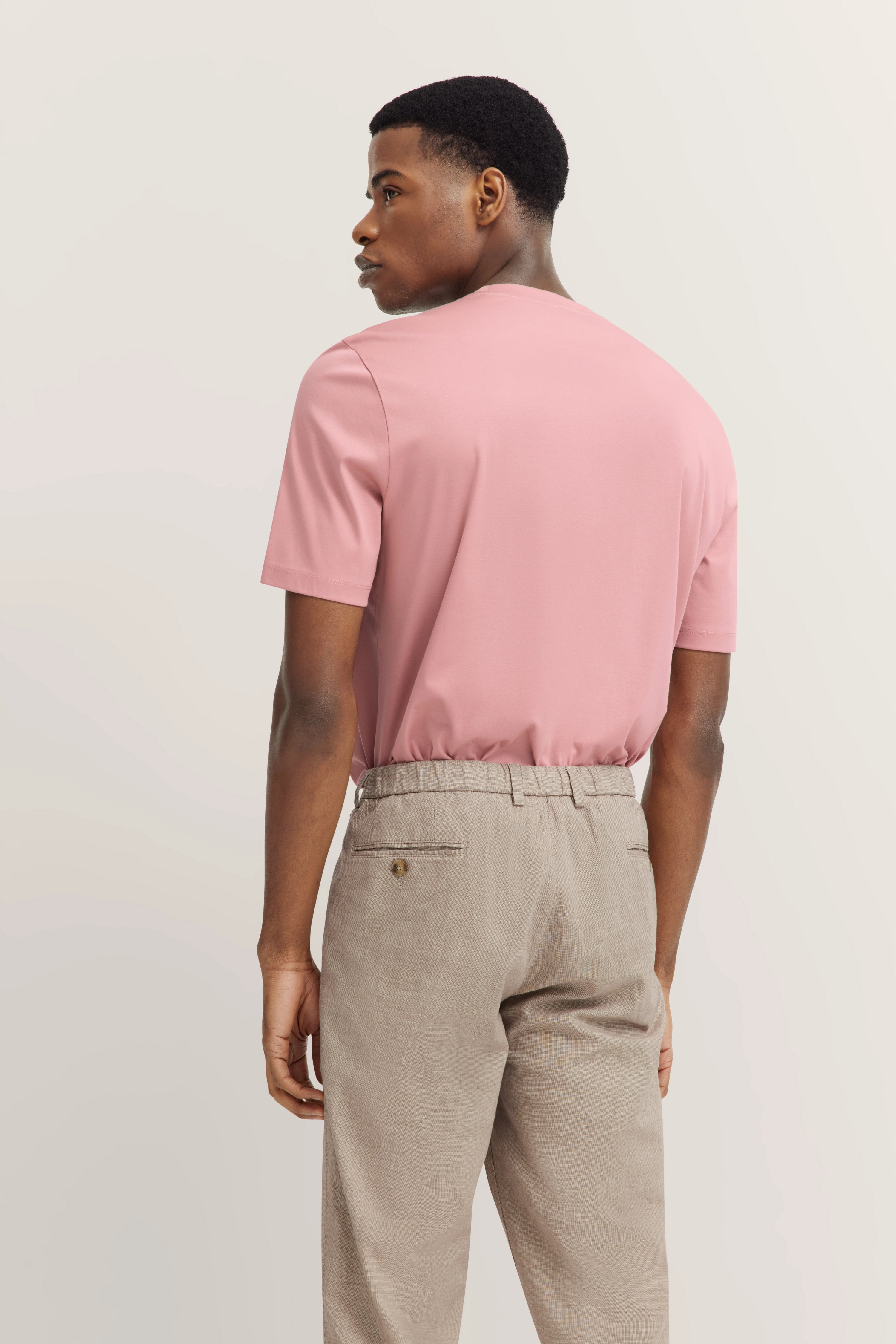 Rear view of model in pink T-shirt and beige pants, casual look, bugatti style.