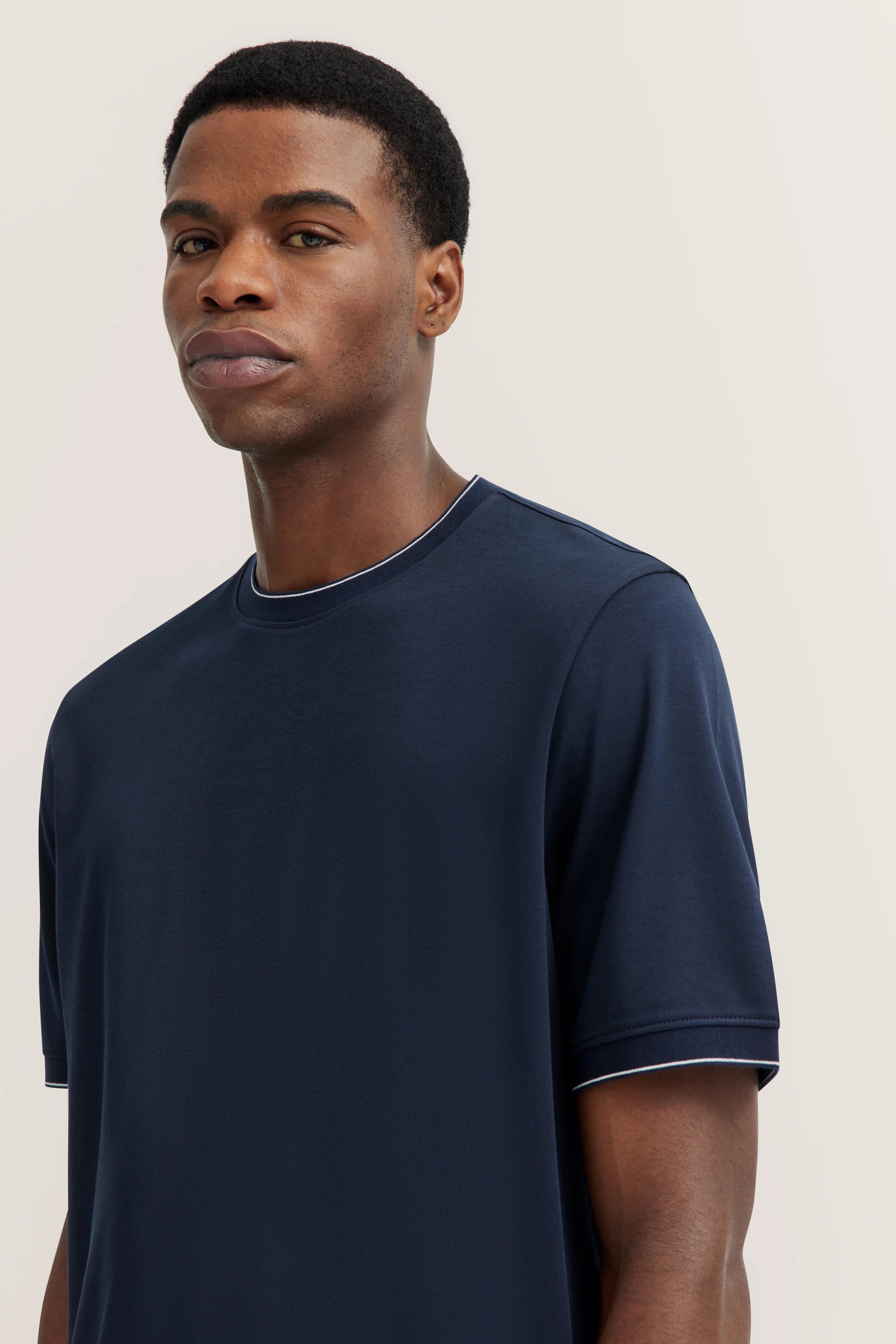 Navy T-shirt by bugatti, model looking slightly sideways.