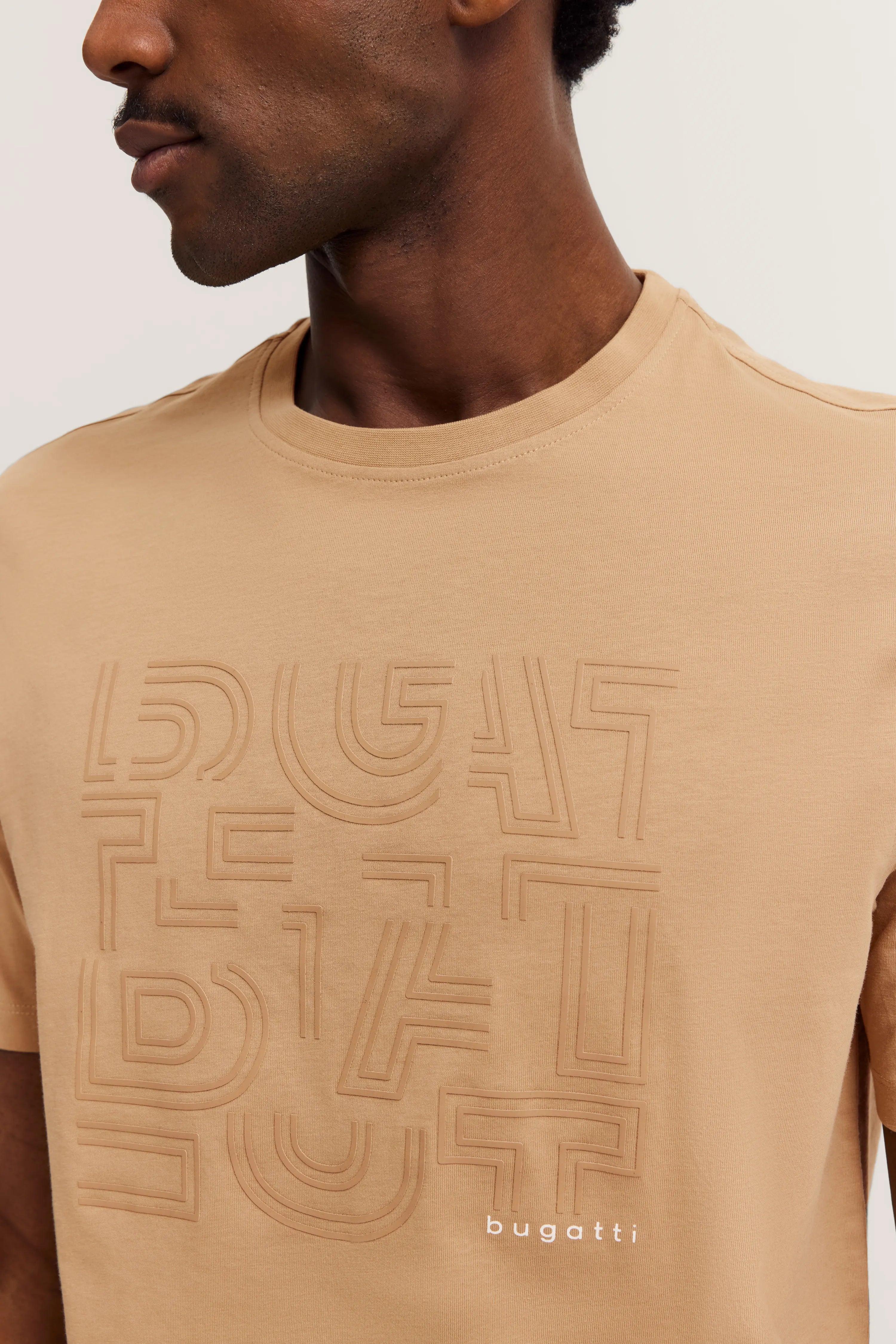 Beige bugatti T-shirt with embossed pattern, model image, side view.