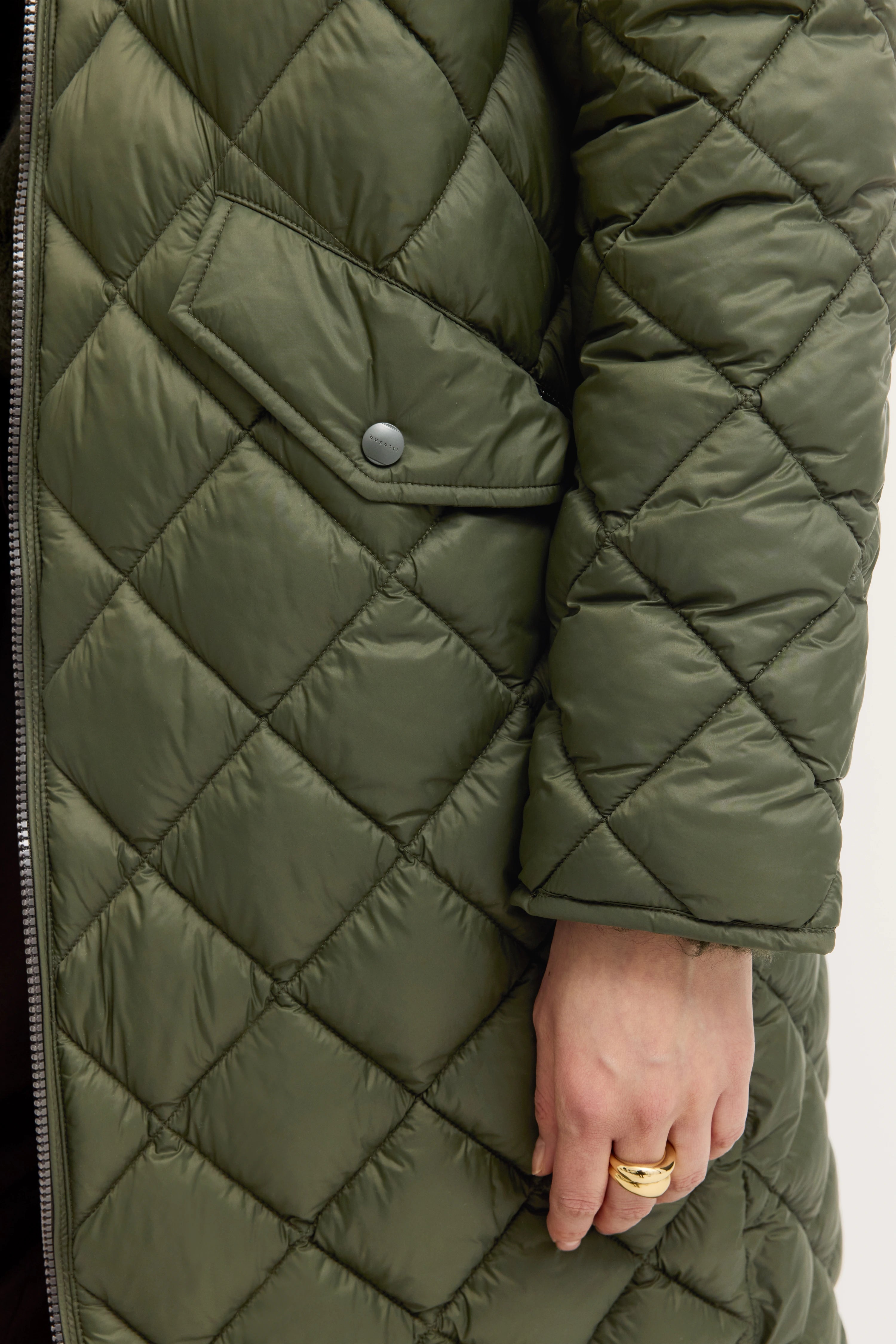 Grüne, gesteppte bugatti-Jacke, Close-up, legeres Bild, Fokus auf Textur und Design.